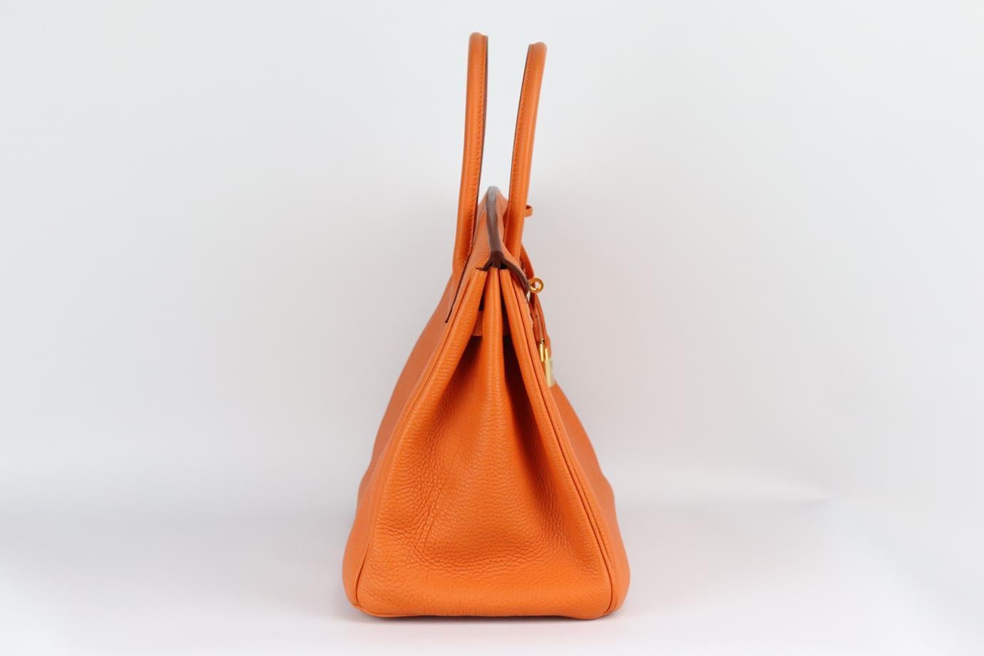 Hermès 2010 Birkin 35cm Veau Togo leather bag. Made in France, this beautiful 2010 Hermès ‘Birkin’ handbag has been made from orange-tone ‘Veau Togo’ leather exterior in ‘Orange’ with matching leather interior, this piece is decorated with gold-tone
