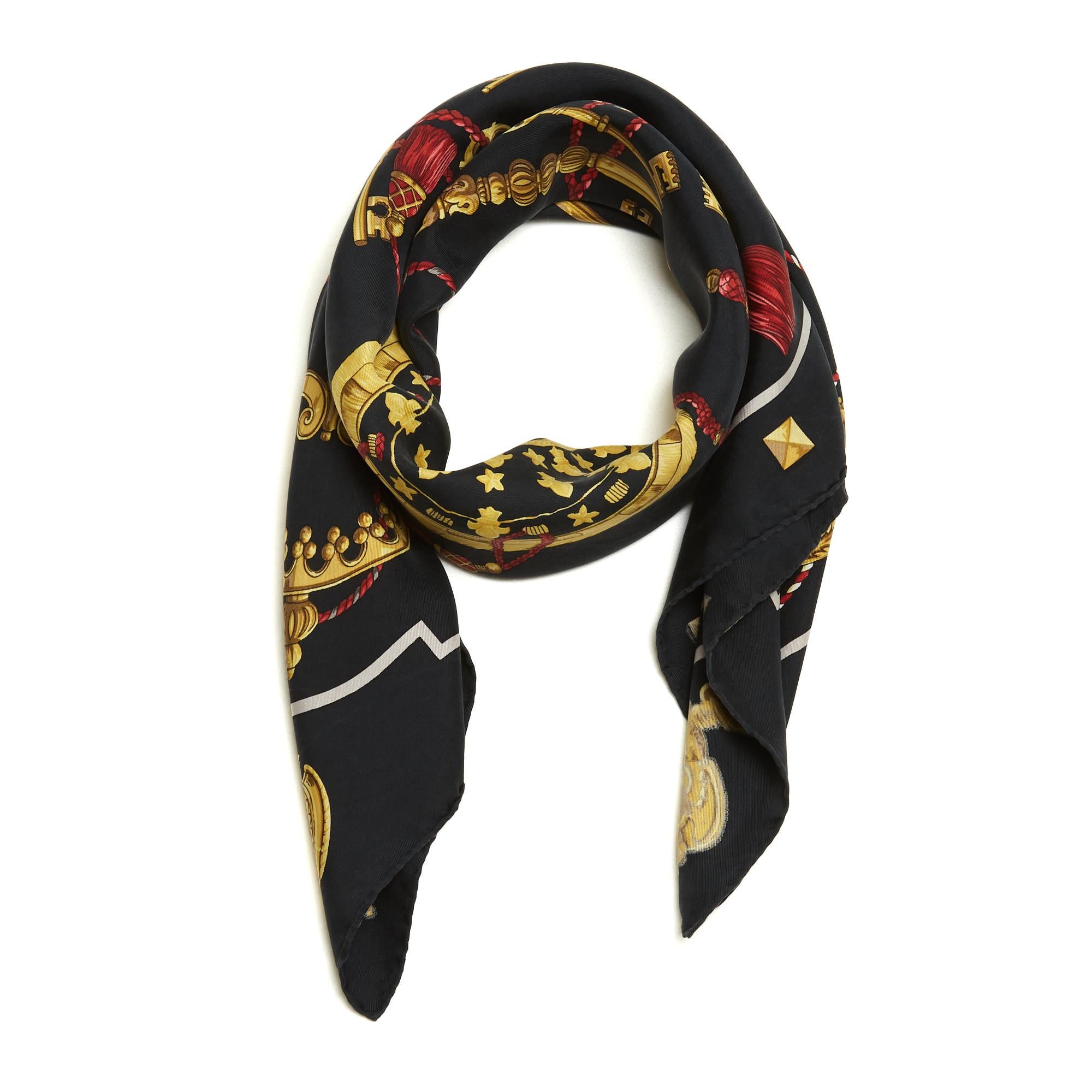 Carré Hermès 90 en sergé de soie, motif Les Clés de Cathy Latham, publié en 1965 et réédité en 1980 puis en 2010 (comme celui-ci), dans les tons or sur fond noir, bordure noire. Largeur 90 cm x longueur 90 cm environ. L'écharpe a été portée et elle
