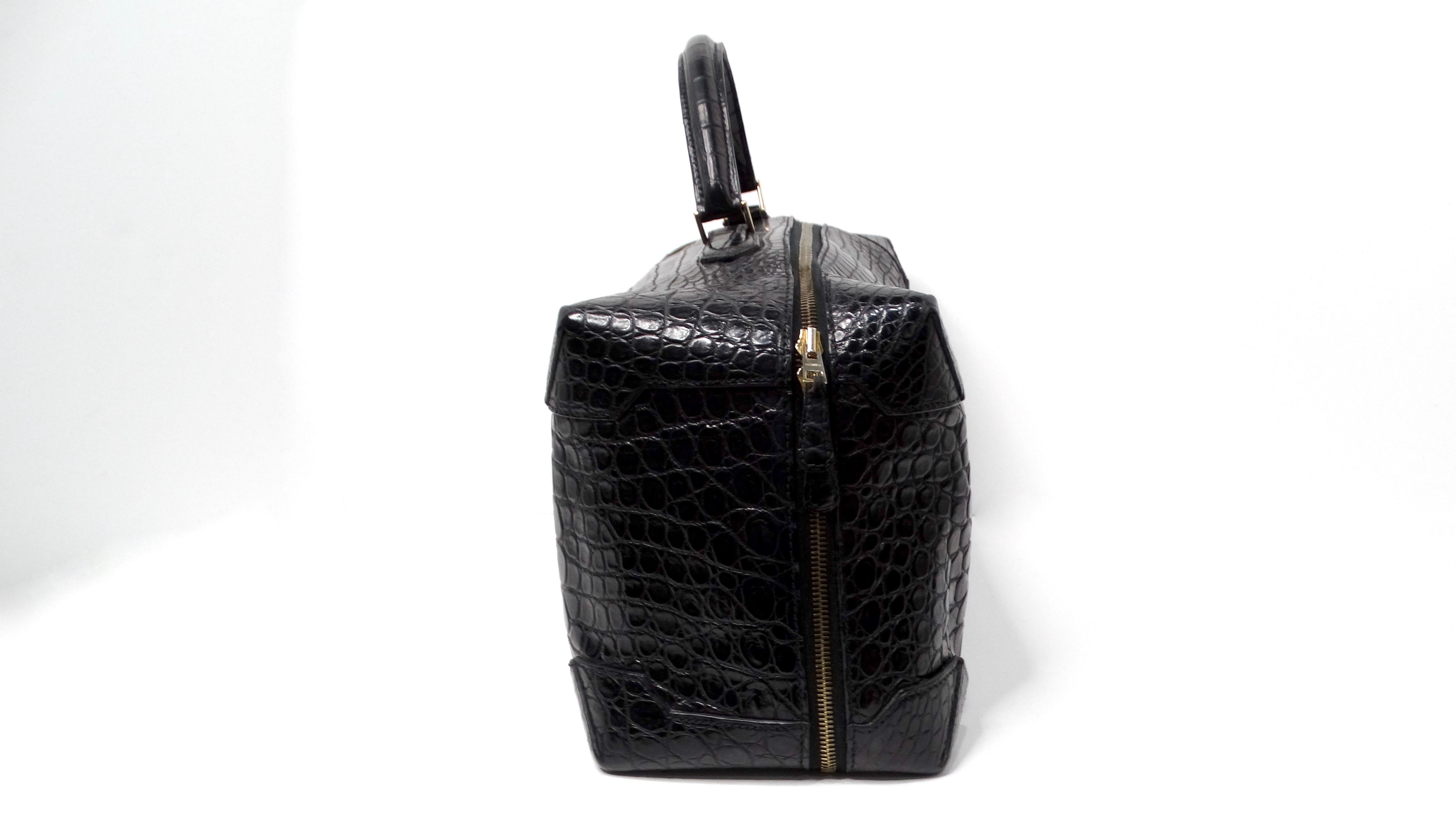 The Hermes 2013 Black Mailbox Cube Q Square Porosus Crocodile Leather Handbag is a stunning and rare accessory that embodies luxury and elegance. Crafted from exquisite black crocodile leather, this duffle-style handbag features a distinctive