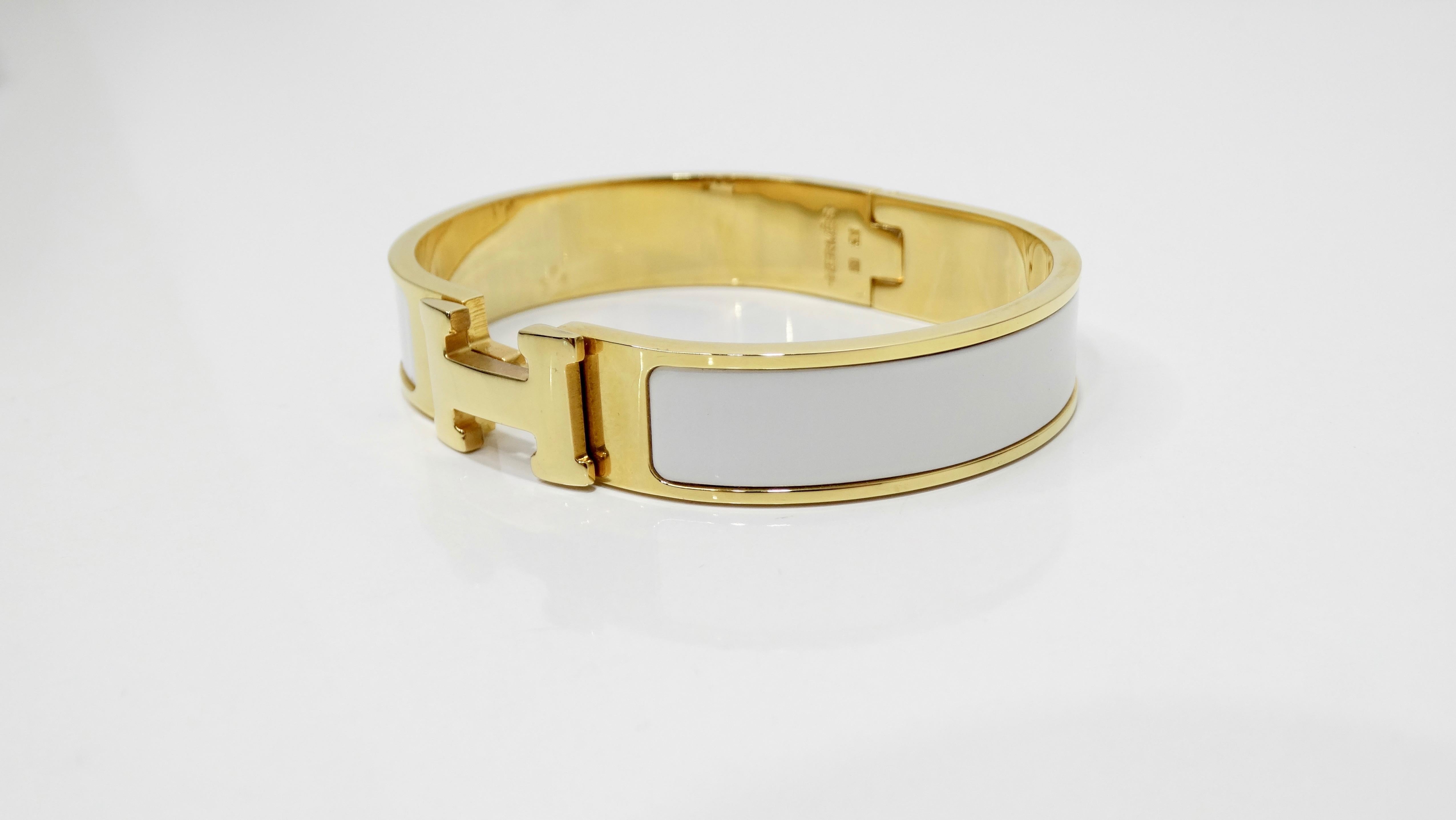 Add this classic Hermés bracelet to your collection! Circa 2013 and one of Hermés most popular accessories, this clic-clac H bracelet features gold-plated palladium hardware, white enamel exterior, and an 