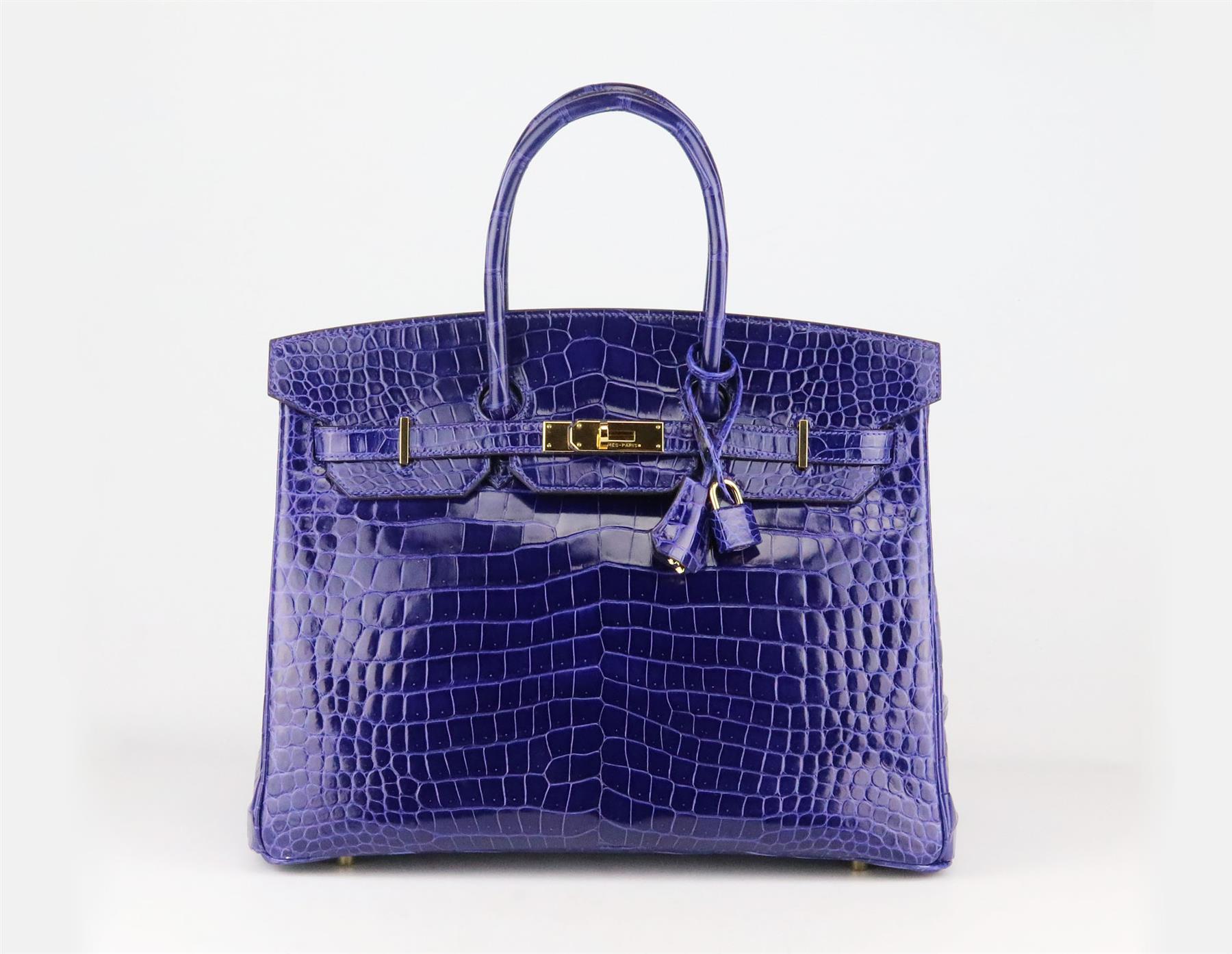 <ul>
<li>Fabriqué en France, ce magnifique sac à main Hermès 'Birkin' 35cm 2014 a été réalisé en crocodile Porosus brillant en 'Royal Blue' et intérieur en cuir assorti, cette pièce est décorée d'une quincaillerie dorée sur le devant et se termine