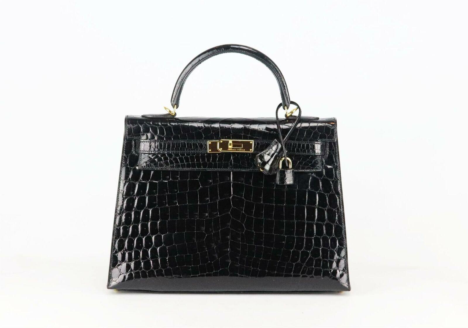 Made in France, this beautiful 2014 Hermès ‘Kelly Sellier’ 32cm handbag has been made from shiny Porosus Crocodile exterior in black and matching leather interior, this piece is decorated with gold hardware on the front and finished with top handle
