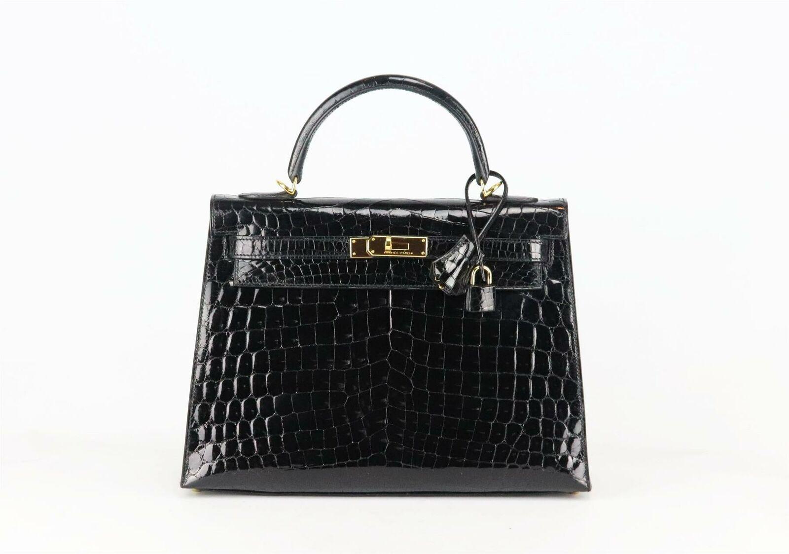 Realizzata in Francia, questa bellissima borsa 2014 Hermès 'Kelly Sellier' da 32 cm è stata realizzata in coccodrillo Porosus nero lucido all'esterno e in pelle abbinata all'interno; questo pezzo è decorato con finiture dorate sul davanti e rifinito