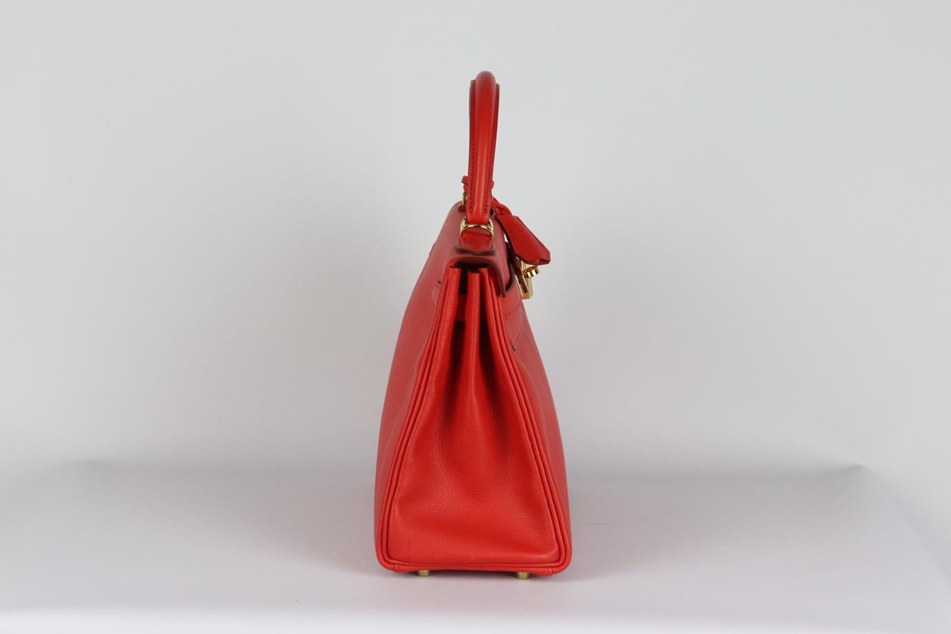 Hermès 2016 Kelly Retourne 28cm Evergrain leather bag. Made in France, this beautiful 2016 Hermès ‘Kelly’ 28cm handbag has been made from red tone ‘Evergreen’ leather exterior in ‘Rouge Casaque’ with matching interior, this piece is decorated with