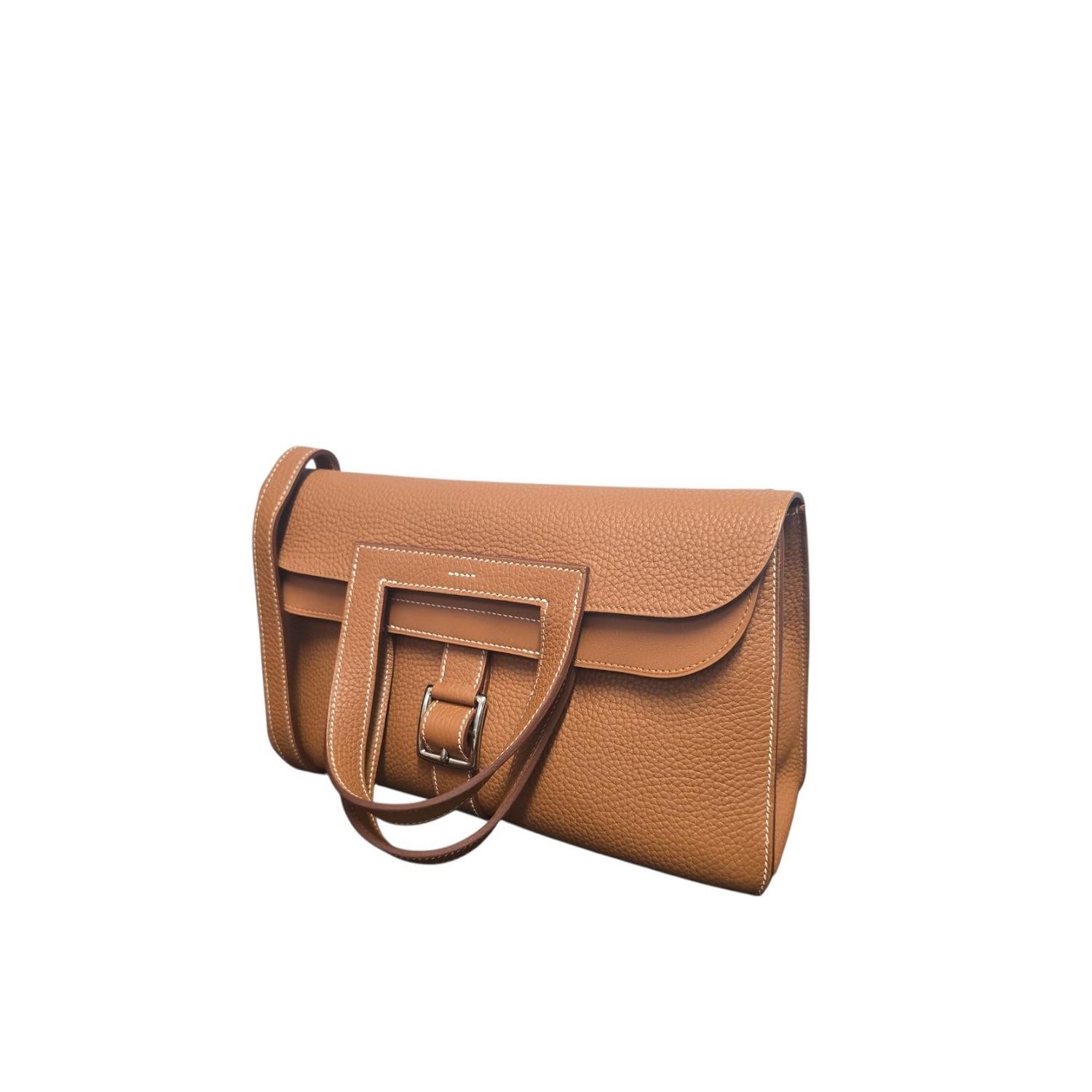 The Hermes 2017 Gold Taurillion Clemence Halzan 31 Bag features soft Taurillion Clemence leather in a classic gold shade. It measures 12.2