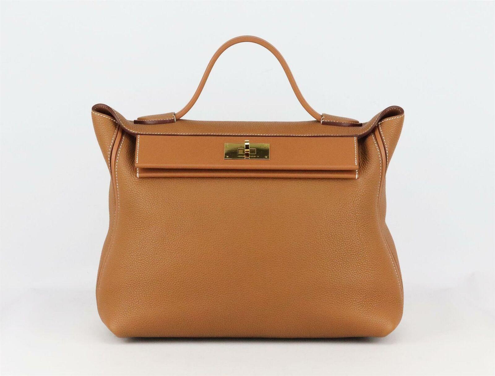 Made in France, this beautiful 2019 Hermès ‘24/24’ 35cm handbag has been made from soft tan Taurillon Maurice and Swift leather exterior and Swift leather interior, this piece is decorated with gold hardware on the front and finished with leather
