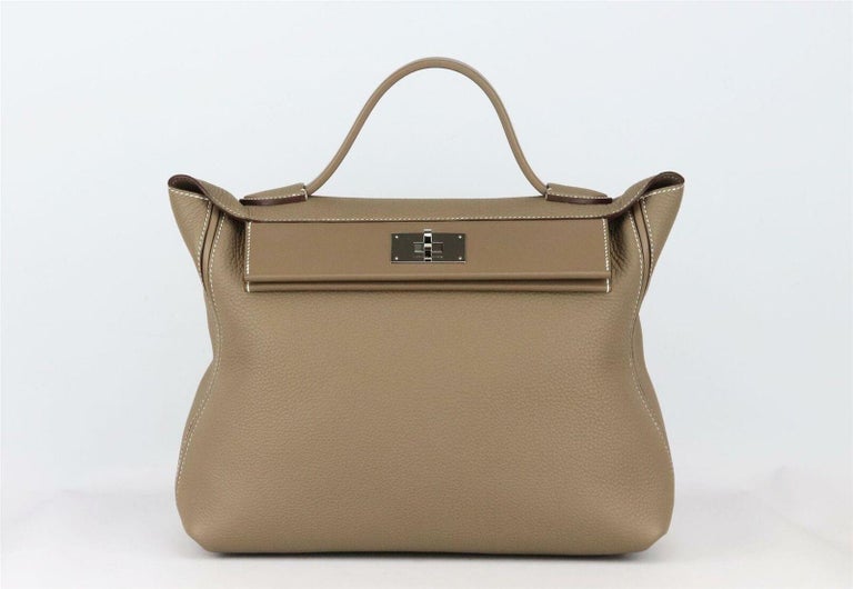 Made in France, this beautiful 2020 Hermès ‘24/24’ 35cm handbag has been made from soft taupe Clemence and Swift leather exterior and Swift leather interior, this piece is decorated with palladium hardware on the front and finished with leather flat