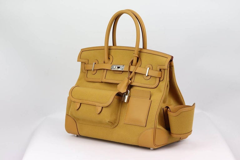 Made in France, this beautiful 2021 Hermès ‘Birkin’ 35cm ‘Cargo’ handbag has been made from toile canvas and ‘swift’ leather exterior in 'Sesame', a tan hue and matching leather interior, this piece is decorated with palladium hardware on the front