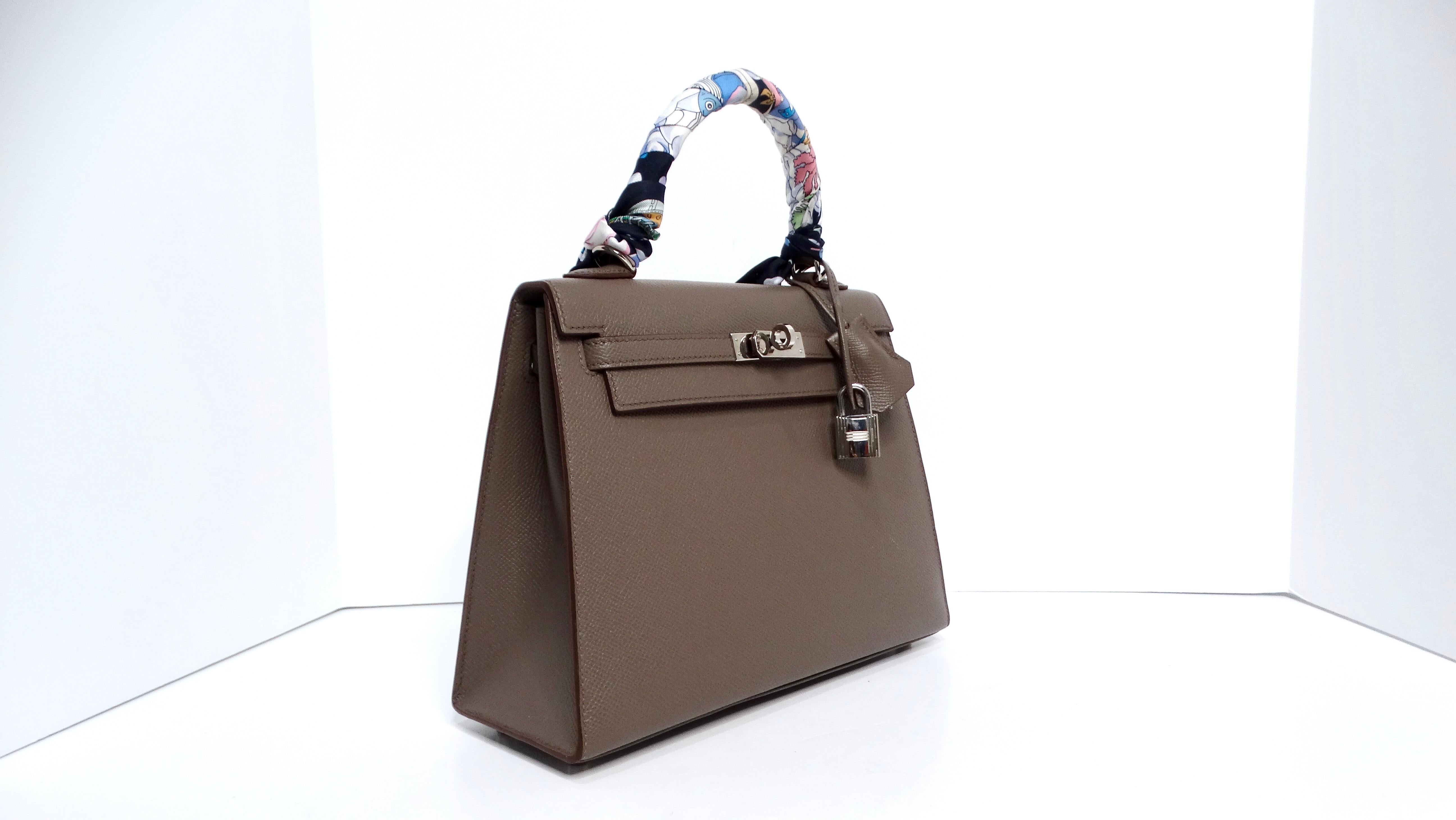Il modello Hermès 2023 Kelly Gray Epsom Sellier 25 con finiture in palladio è un pezzo di grande prestigio che incarna un'eleganza senza tempo e una maestria superiore. Questa borsa da 25 cm è realizzata in lussuosa pelle Epsom, con una bellissima