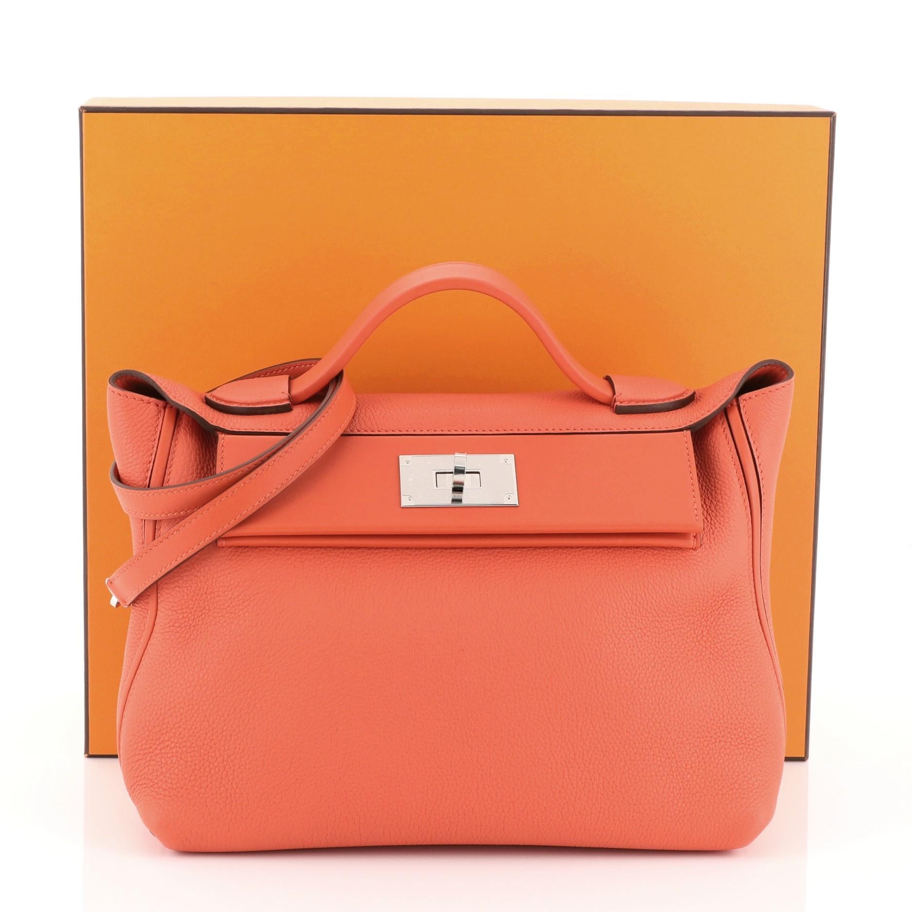 This Hermes 24/24 Handbag Togo with Swift 29, crafted in Capucine red Togo and Swift leather, features a leather top handle, exterior back slip pocket and palladium hardware. Its turn-lock closure opens to a Capucine red Swift leather interior with