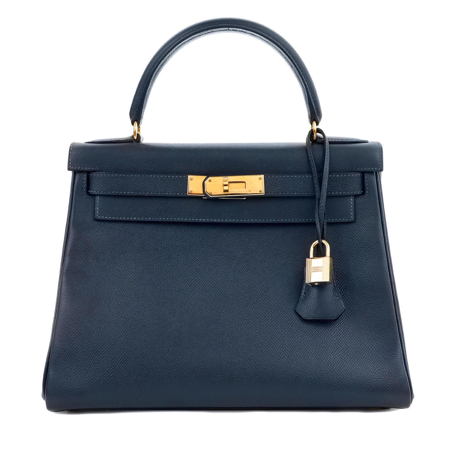 This authentic Hermès 28 cm Midnight Blue Epsom Leather Kelly is in excellent condition.  The ladylike Kelly is in high demand and requires extensive waiting periods from Hermès.  Classic deep navy blue paired with gold hardware is a timeless