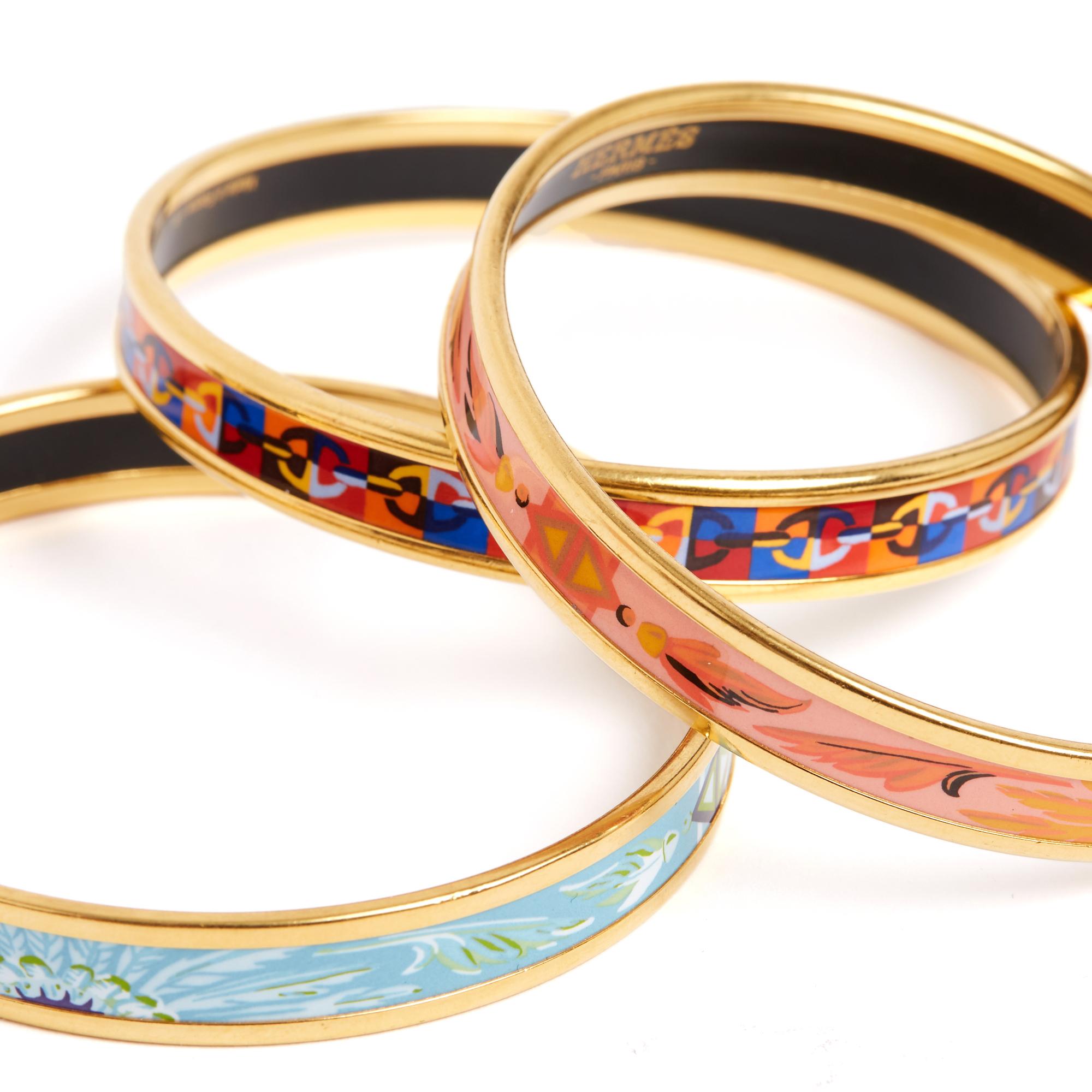 3 braccialetti Hermès, modello Fin, in smalto stampato: 1 motivo Brasile in azzurro + 1 motivo Brasile in rosa salmone + 1 motivo catena ad ancora multicolore. Misura 65: diametro interno 6,3 cm, altezza 0,9 cm (ciascuno). I bracciali sono stati