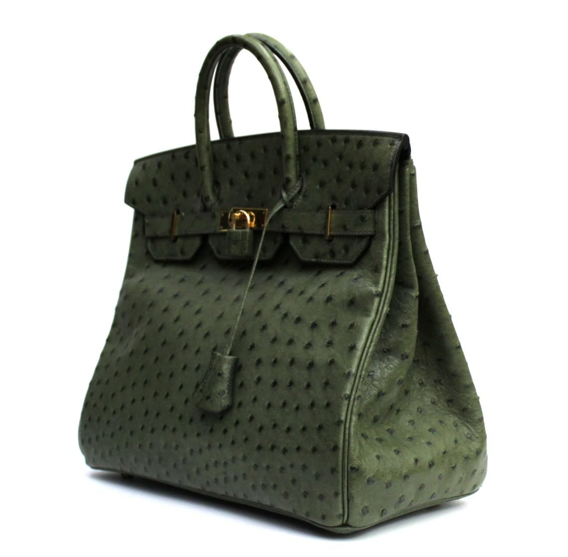 This lovely handbag is crafted of beautifully textured ostrich leather in dark green. The bag features rolled top handles, a crossover flap with a strap closure and gold hardware including a turn lock, a padlock and a hanging clochette with keys.