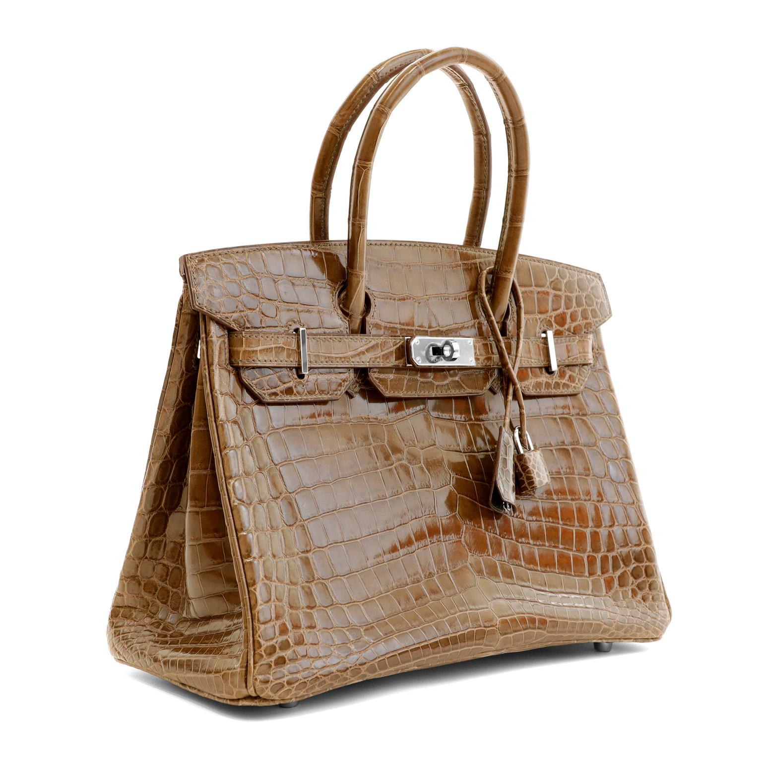 This authentic Hermès 30 cm Gris Elephant Crocodile Birkin is in pristine unworn condition, never before carried.  The protective plastic is intact on the hardware and it has been meticulously stored.   Hermès bags are considered the ultimate luxury