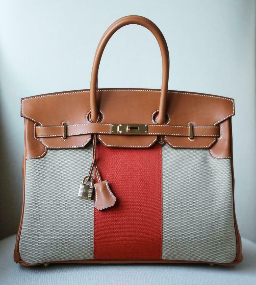 This extremely beautiful Limited Edition Hermès 35cm Flag Barenia Toile Birkin Bag with Permabrass Hardware is a must have for your collection! 
The beautiful rich tan leather exterior with orange and neutral toiles well with many pallettes.
The bag