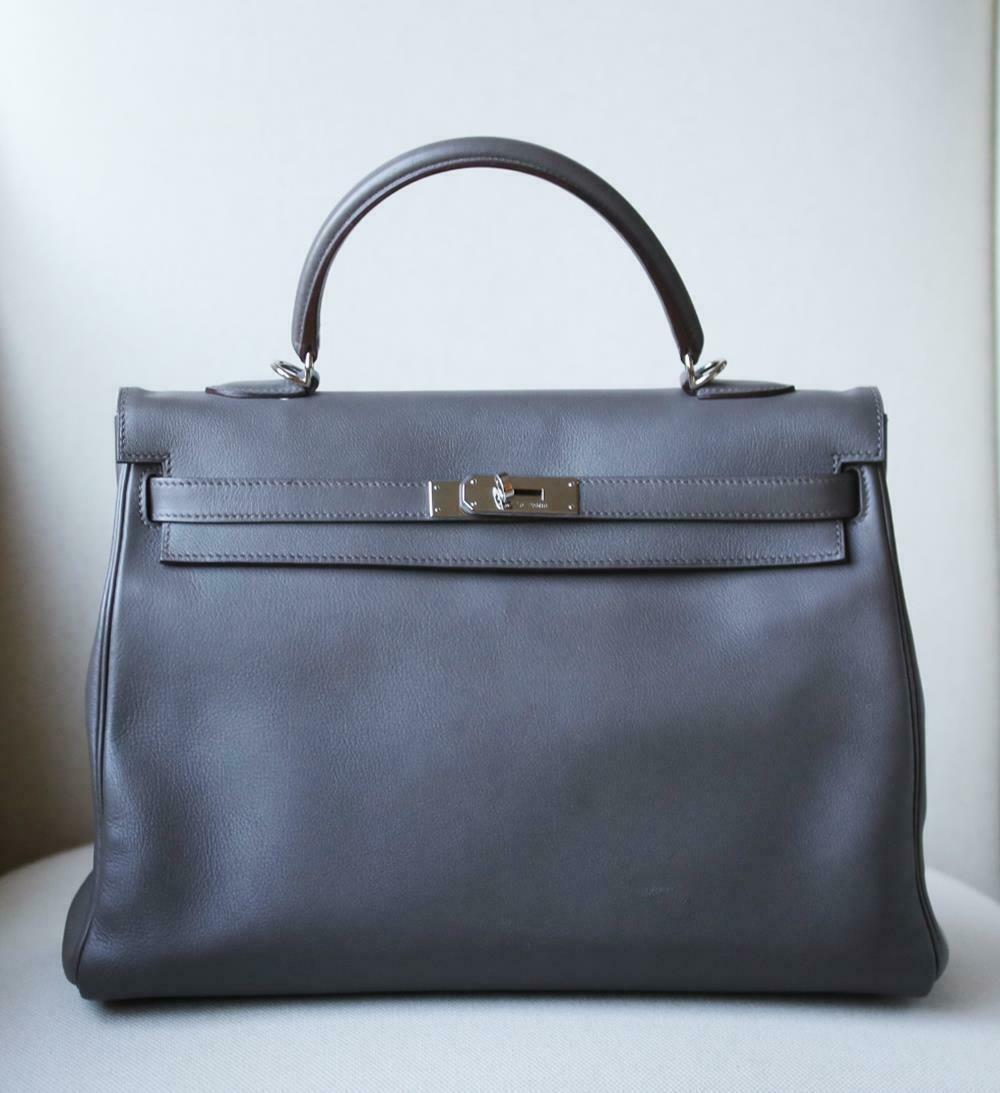 This extremely beautiful Hermès Kelly Retourne 35cm Swift Bag in Etain with Palladium Hardware is a must have for your collection! 
The beautiful rich grey-tone exterior of the bag works well with every outfit.
Tonal stitching.
The bag is crafted