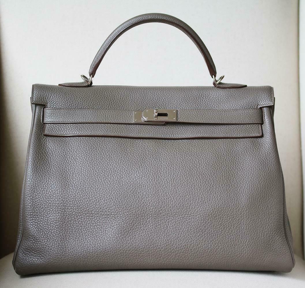 This extremely beautiful Hermès Kelly Retourne 40 Clemence Bag in Etain with Palladium Hardware is a must have for your collection! 
The beautiful rich grey-tone exterior of the bag works well with every outfit.
Tonal stitching.
The bag is crafted