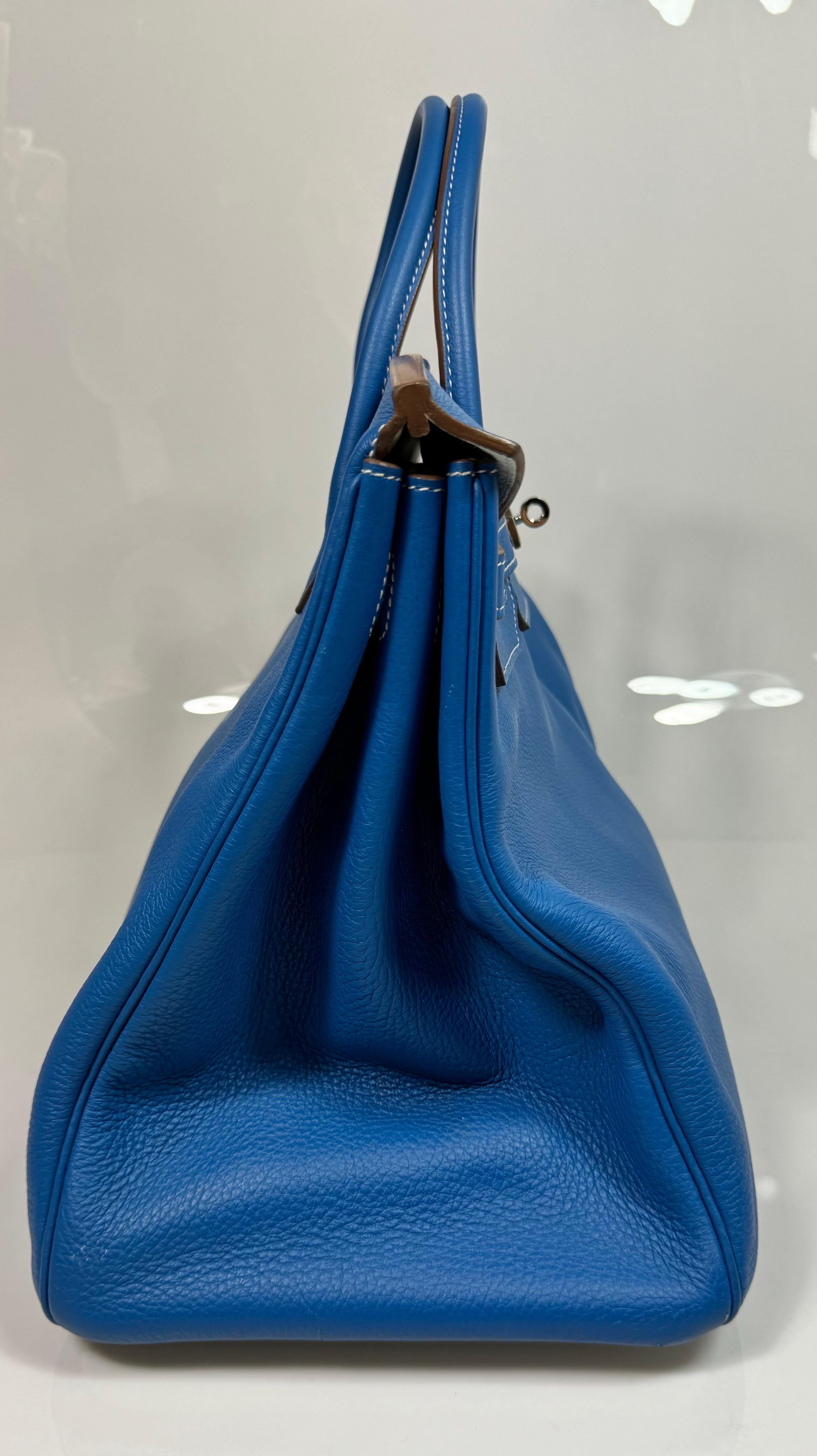This is an authentic limited edition HERMES 40cm Clemence Leather Mykonos Blue and White Birkin with Silver Hardware is from 2011 with an O inside a square. This bi-color limited edition Birkin handbag is hard to find and a perfect addition to any