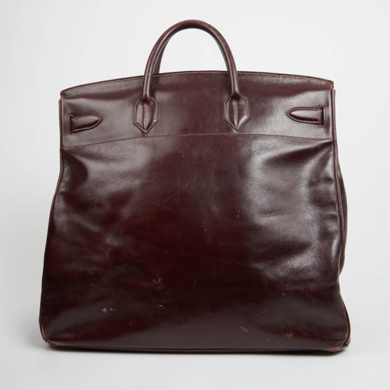 Big brother of the inevitable Birkin, this vintage Courroies Top is in dark burgundy box leather, size 45. It was originally designed to make life easier for riders, then declined in handbag format in the 80s This large bag has its padlock, bell,