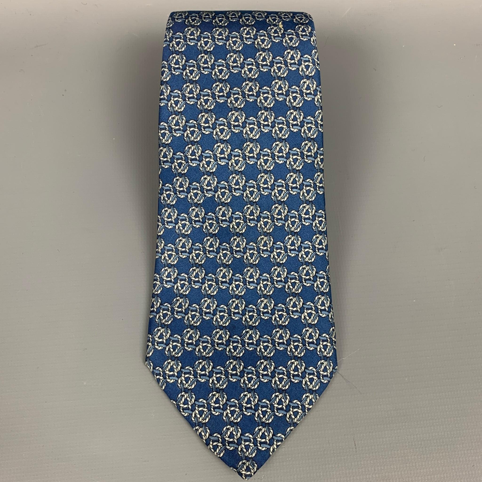 HERMES neck tie comes in a ble & cream kno print silk. Made in France.

Very Good Pre-Owned Condition.
Marked: 792 MA

Measurements:

Width: 3.5 in.  