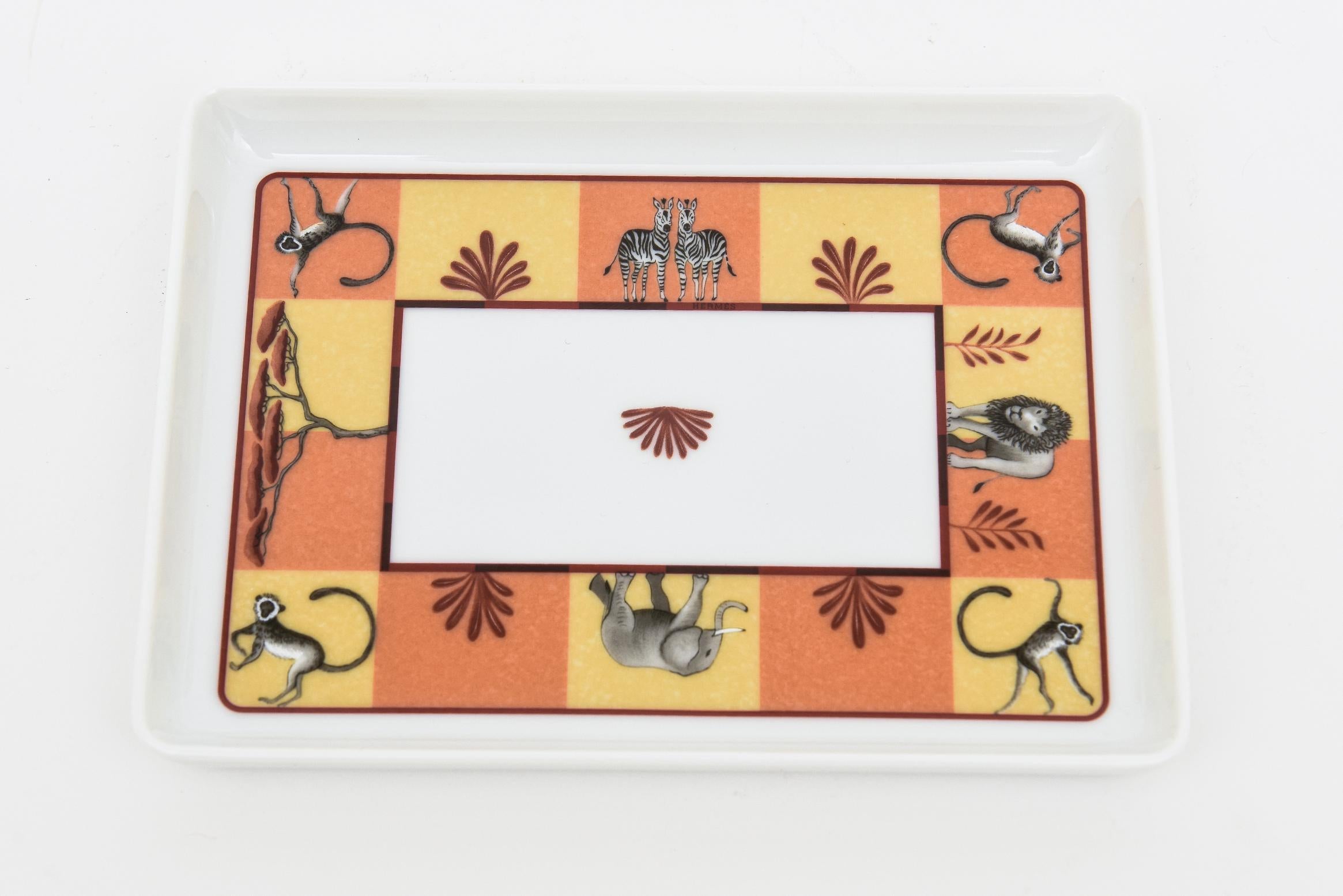 This delightful and colorful hallmarked Hermes porcelain tray, ring tray or dish is rare. It is from the Africa series depicting many animals of safari design. It is from the 90's. 
Colors are orange, yellow, black, etc.