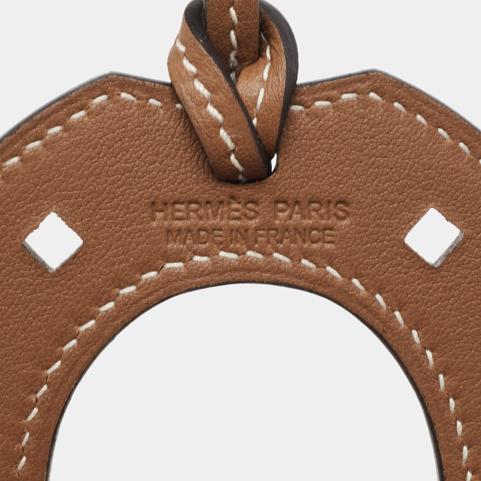Paying homage to its equestrian heritage, this 'Paddock Fer a Cheval' bag charm from Hermès is a classy accessory to own. It is crafted using Swift leather and hangs from a strap. Needless to say, this Hermès bag charm will add a signature touch to