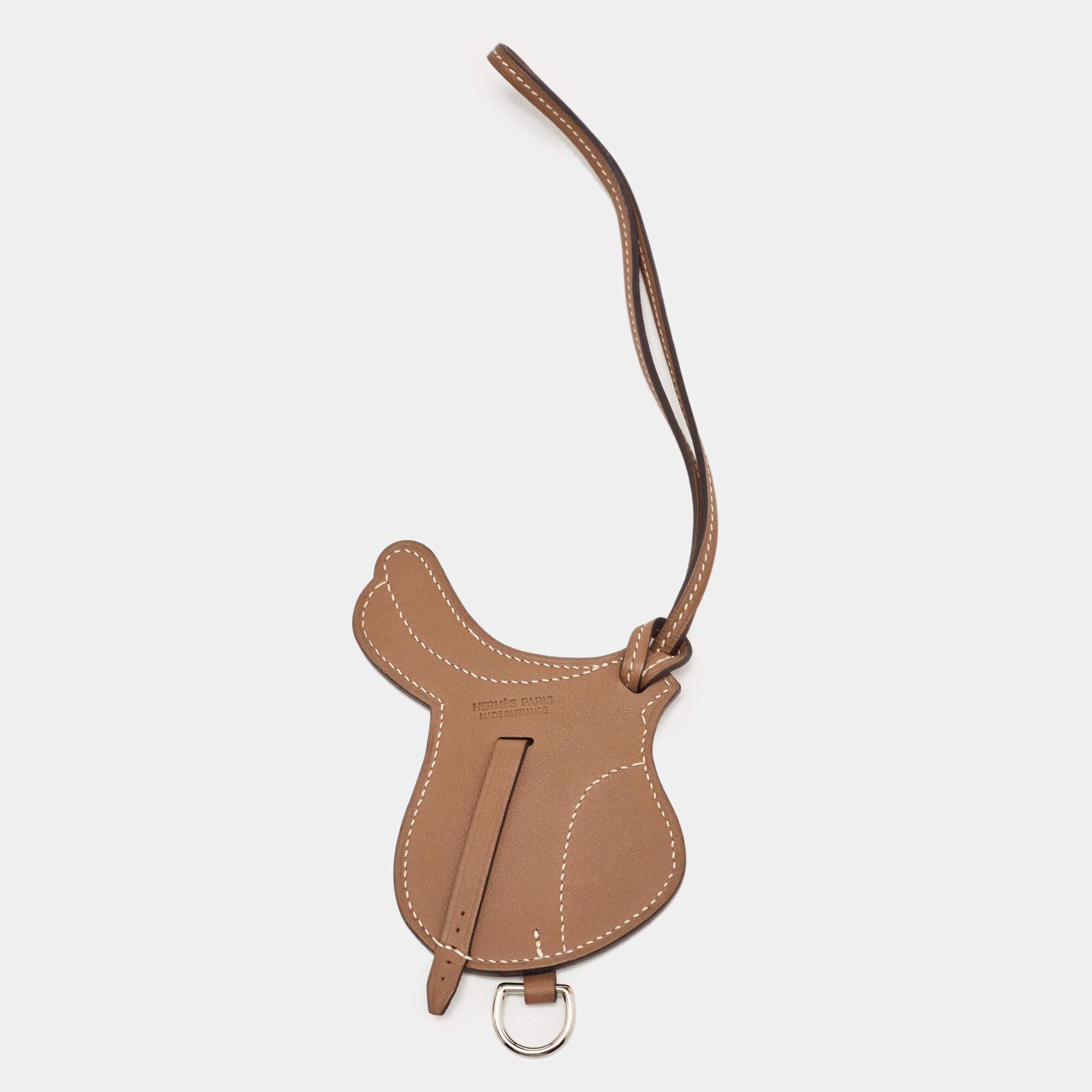The Hermès Paddock Selle bag charm is an exquisite accessory crafted from luxurious Swift Leather. Its design features a luxe shade. This charming piece perfectly complements any Hermès bag, adding a touch of elegance and sophistication.

