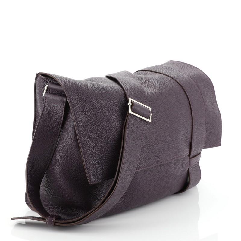 This Hermes Alfred Messenger Bag Clemence 35, crafted from Raisin purple Clemence leather, features an adjustable shoulder strap, frontal flap, and palladium hardware. It opens to a neutral fabric interior with side zip and slip pockets. Date stamp