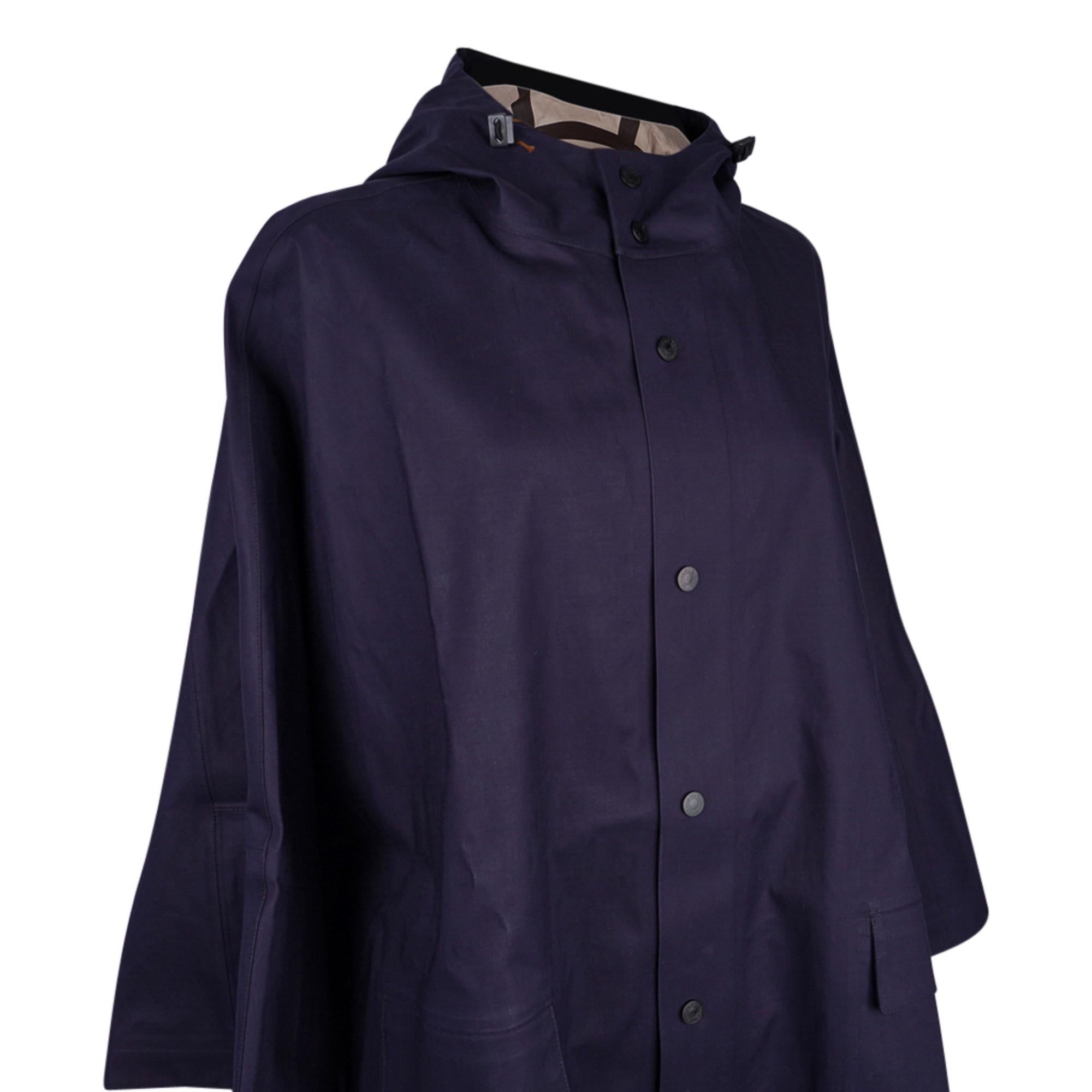 Guaranteed authentic Hermes rain cape that can be worn with or without the sleeves.
Chic Navy with Khaki interior has snap closure.
Light waterproof cape for rider on foot or in the saddle.
Adjustable hood and rear gusset. 
Created from 63% Cotton