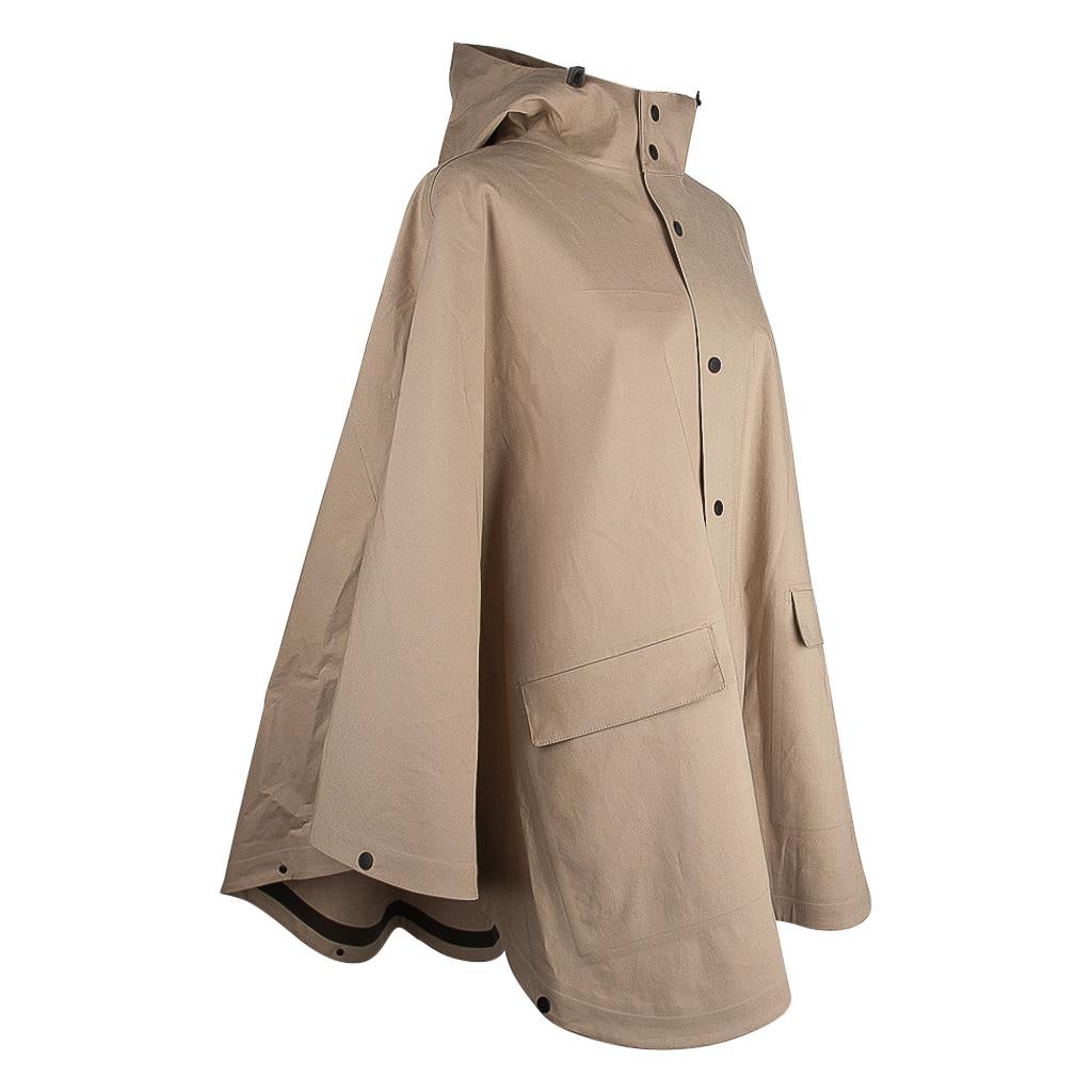Guaranteed authentic Hermes rain cape that can be worn with or without the sleeves.
Chic Khaki with snaps.
Light waterproof cape for rider on foot or in the saddle.
Adjustable hood and rear gusset. 
Created from 63% Cotton and 37% Polyurethane.
This