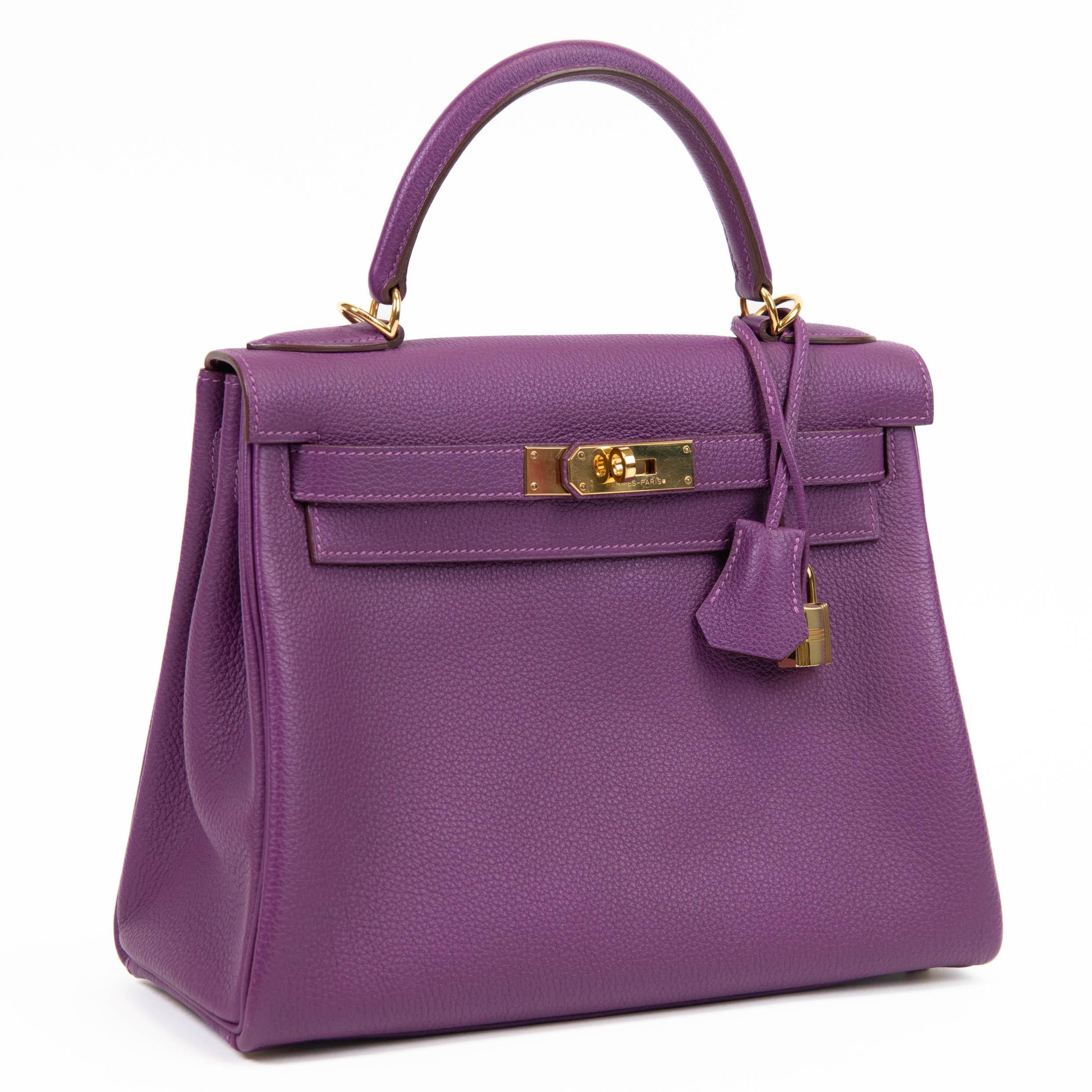 100% auténtico

Este bolso Kelly está confeccionado en piel de becerro togo de rica textura en un precioso tono morado. El bolso tiene un asa superior de piel reforzada con eslabones de herraje chapados en oro. El bolso tiene una correa opcional de