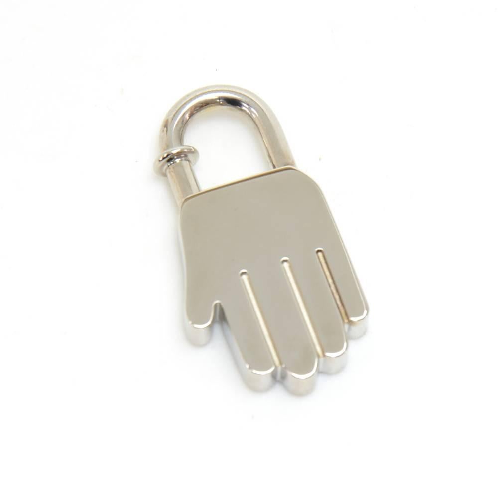 Hermes Silver Tone Hand Motif Cadenas Lock.  It is a Cadenas lock for the front of Herme's  Classic Kelly, Birkin, or Bolide Hand bags. This is the 2002 limited edition Annee De La Main Hand Lock. Has 