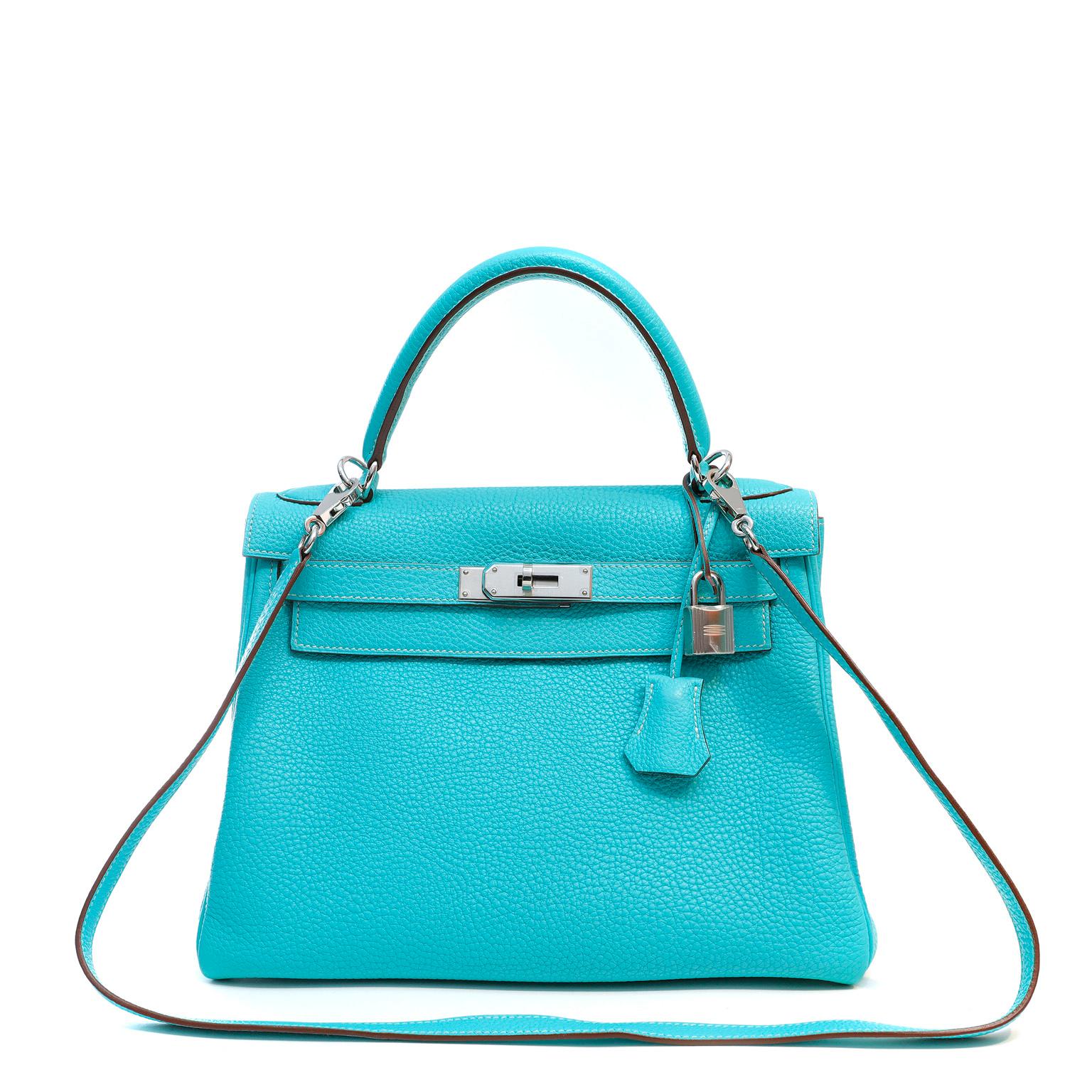 This authentic Hermès Aqua Blue Togo Leather 28 cm Kelly Bag is in pristine condition with the protective plastic intact on the hardware.    Hermès bags are considered the ultimate luxury item worldwide.  Each piece is handcrafted with waitlists