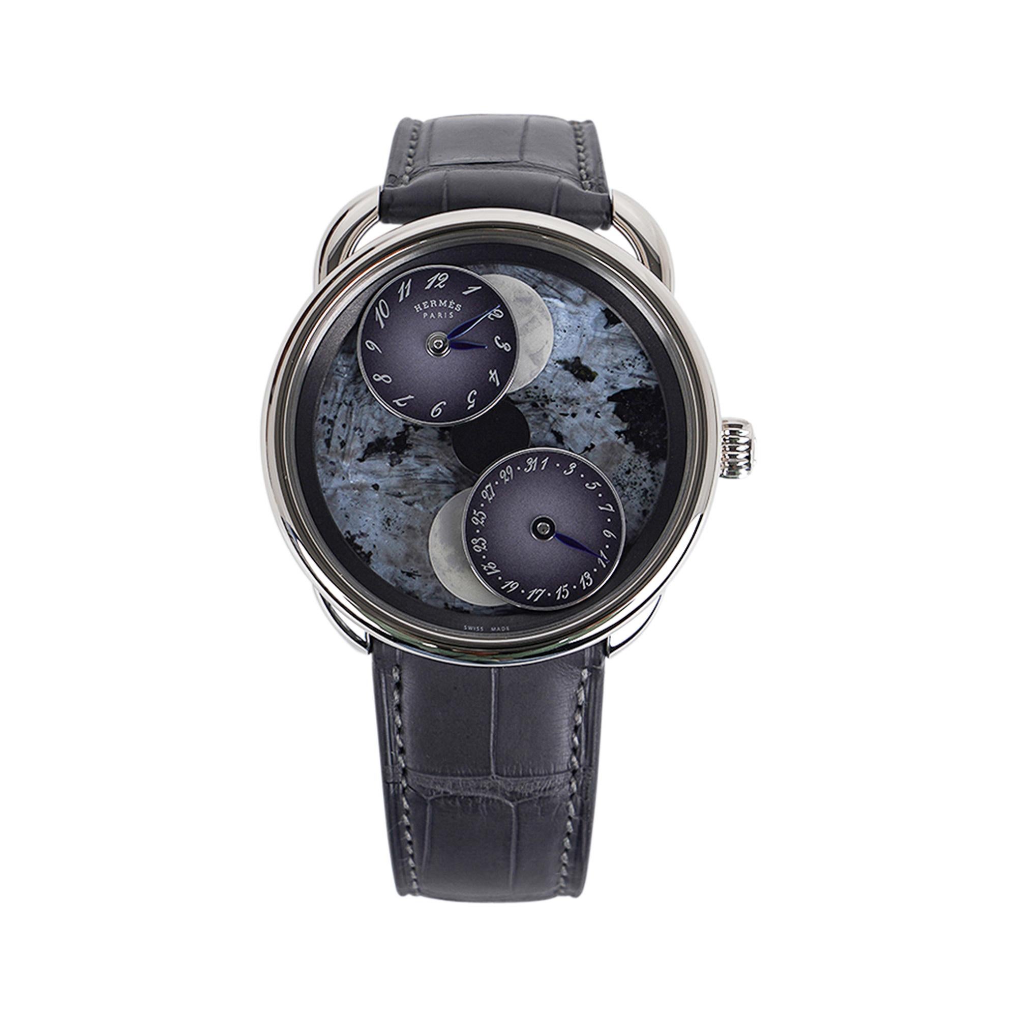 Lose yourself in space and time with this magical creation.
Mightychic offers an exquisite Hermes Limited Edition Arceau L’Heure De La Lune Only double moon phase complication watch.
Featured in Blue Pearl Stone.
Graphite Alligator strap.
The entire