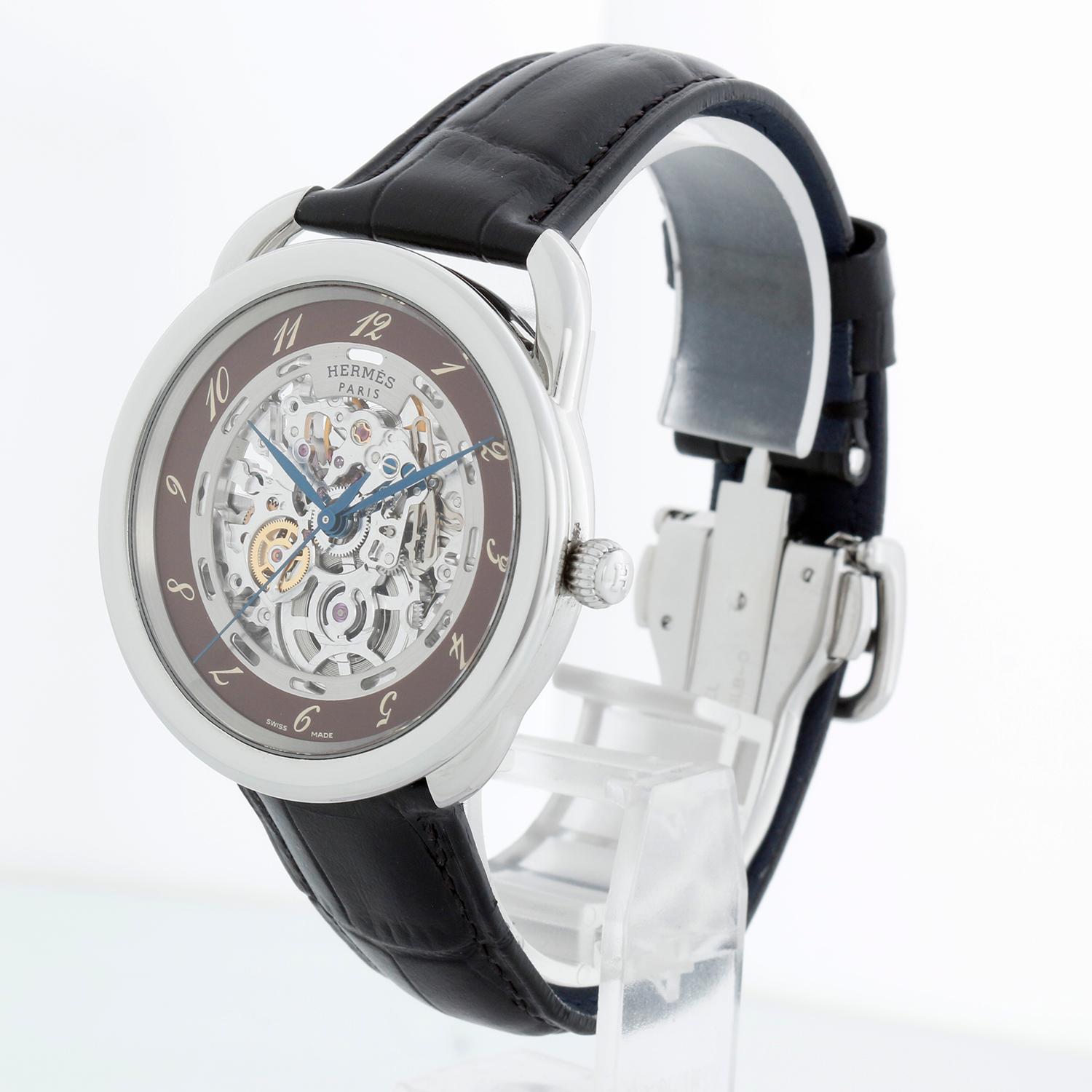 Hermes Arceau Squelette Automatic Watch AR6.710A - Automatic winding. Arceau. Stainless steel ( 41 mm ). Skeleton dial with Arabic numerals. Black alligator strap with stainless steel deployant clasp. Pre-owned with DeMesy box.

