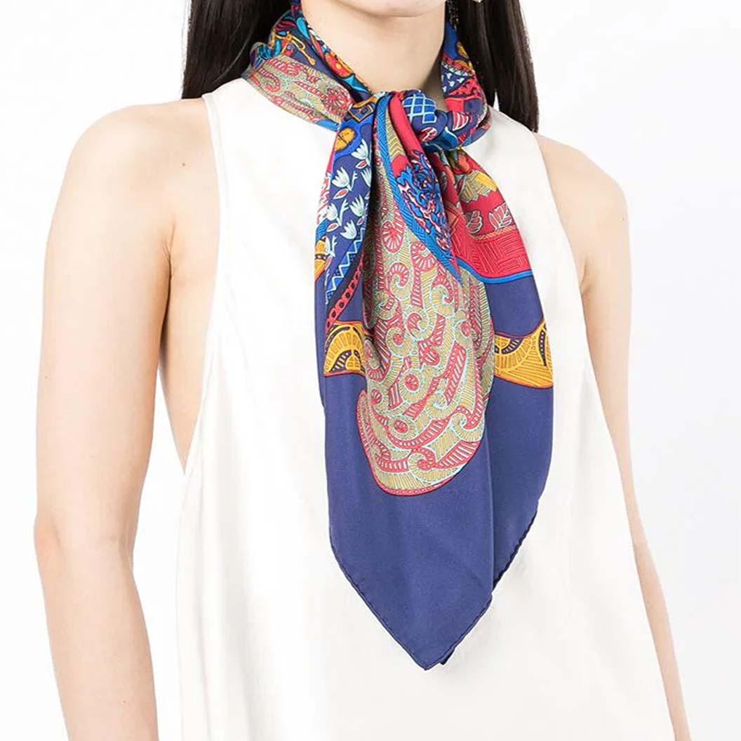 Designed by Annie Faivre in 1991, this pre-owned silk scarf was inspired by the stories about kublai Khan - a Mongolian emperor who lived during the 13th century. The scarf represents a beautiful cavalier scene on a navy background. Delicately
