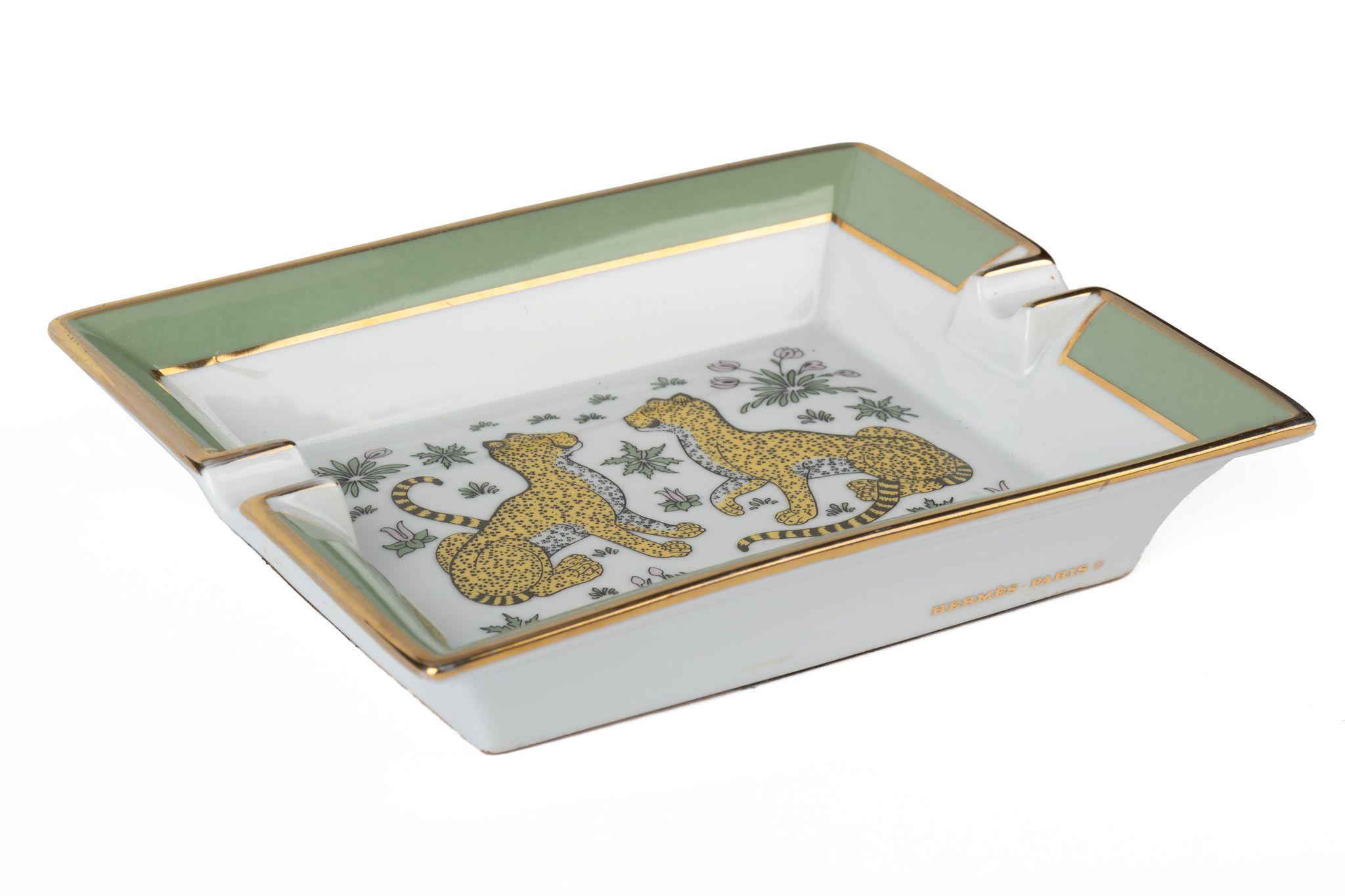 Hermès vintage white ashtray with green edges and two leopards in the center. The edges are colored green. Suede stamped bottom. Comes with original box. Minor wear on bottom suede.