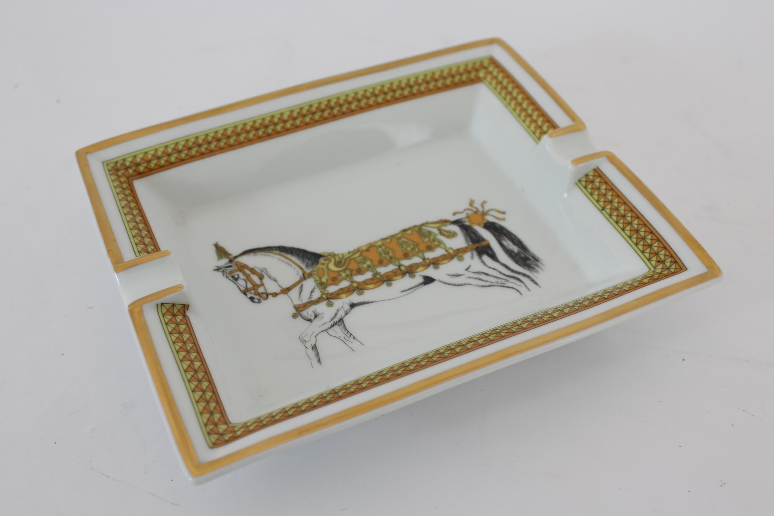 Hermes vintage ashtray 90s. French porcelain, color white and gold with a horse depicted. On the bottom velvet of goat. Made in France. Excellent vintage conditions.

Measures: 19 x 15.5 cm
