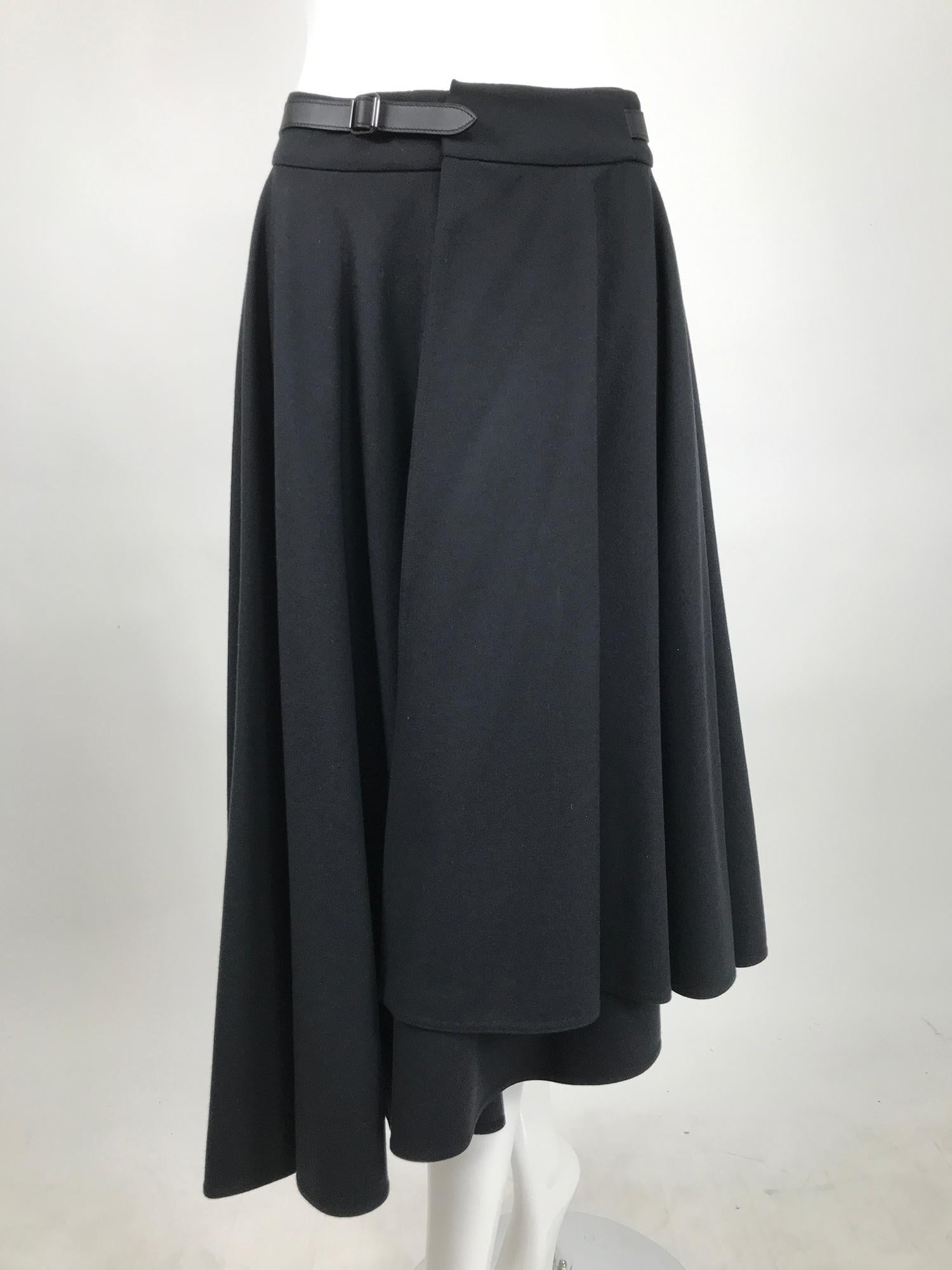 Hermès asymmetrical black wool, full circle wrap skirt. Unique wrap skirt of beautiful light weight black wool. The skirt wraps at the waist with a single button fastening inside and closes at the waist with a soft calf leather belt with buckle. The