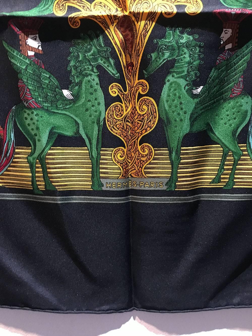 STUNNING Hermes Au Fin de la Soie Silk Scarf in Black in excellent condition.  Original silk screen design c1995 by Annie Faivre features an assortment of mythological creatures and plants in green, gold, and maroons over a black background.  100%