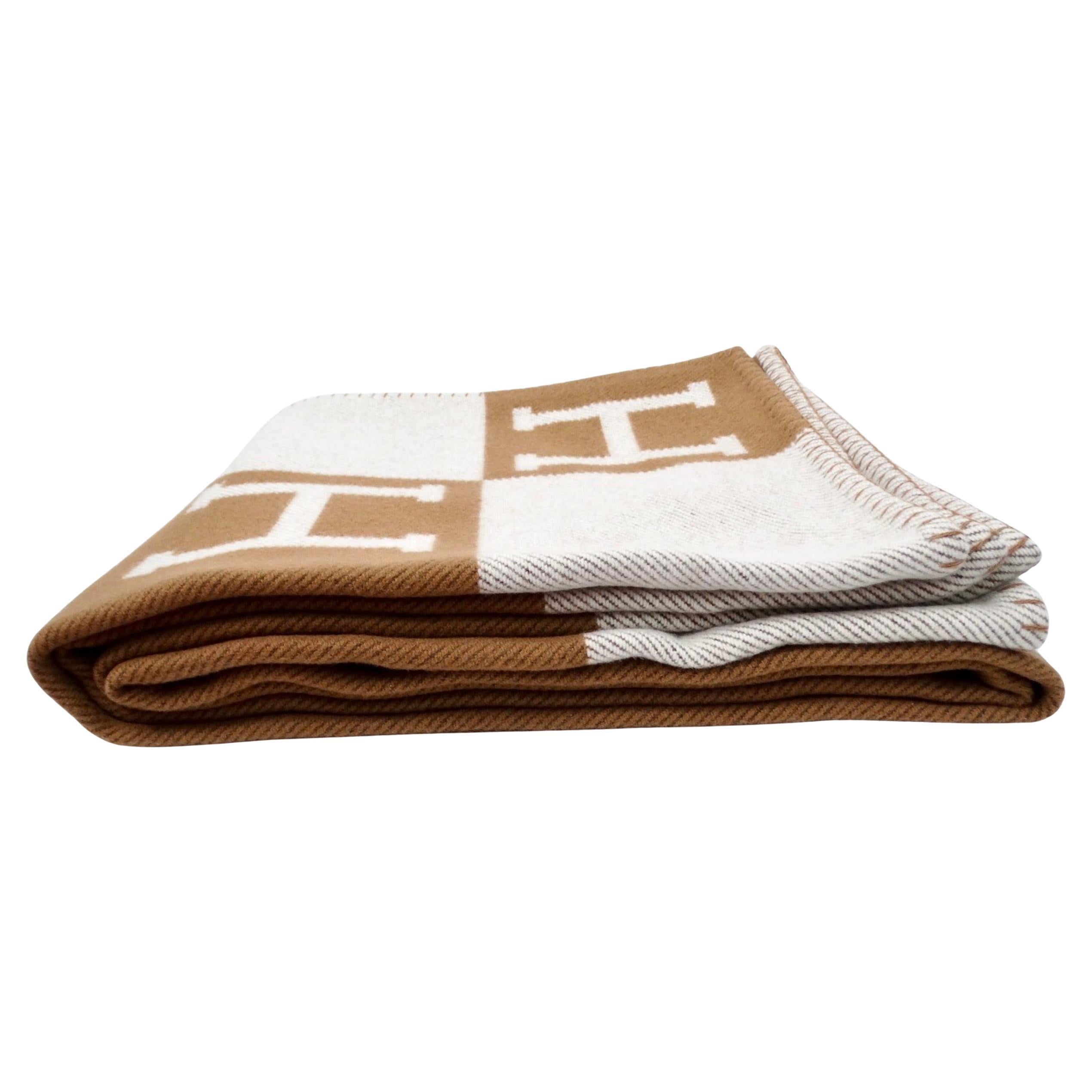 The Hermes Avalon Camel & Ecru Wool & Cashmere Blend Throw Blanket exudes understated luxury and timeless elegance. Crafted from a sumptuous blend of wool and cashmere, this throw offers unparalleled softness and warmth, making it an ideal accessory