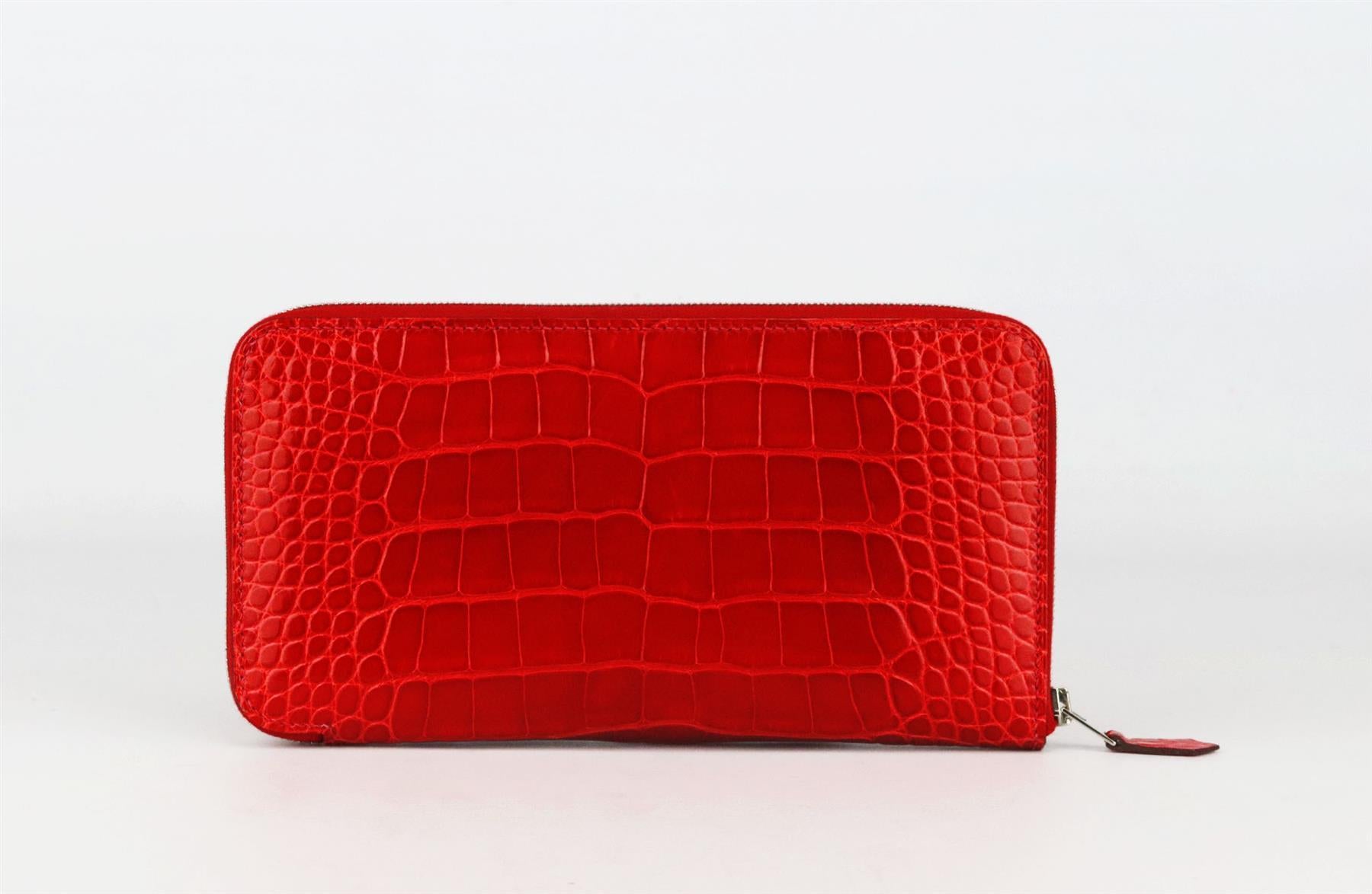Made in France, this beautiful 2013 Hermès ‘Azap’ wallet has been made from shiny Alligator Mississippiensis exterior in red and matching leather interior, it is decorated with palladium H hardware on the zip and finished with 12 card slots, 2 bill