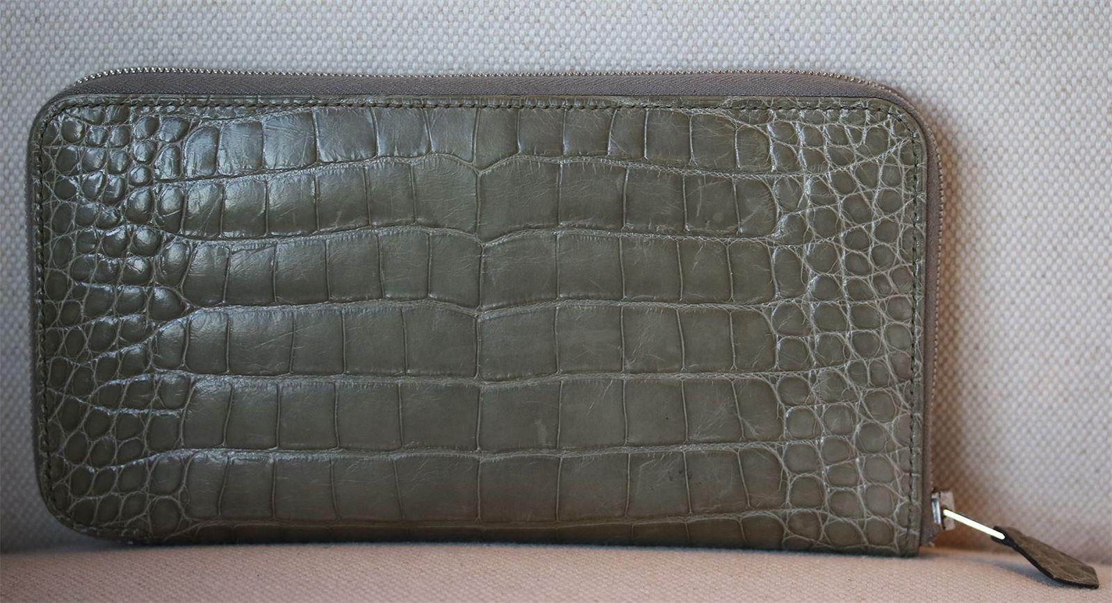 Wallet in crocodile skin, silver- and palladium-plated zip. Inside: ten credit card slots and a zippered change pouch.

Dimensions: Approx. 11 x 20 x 1.5 cm 

Condition: Slight marks to the leather; see pictures. Otherwise, no sign of wear.