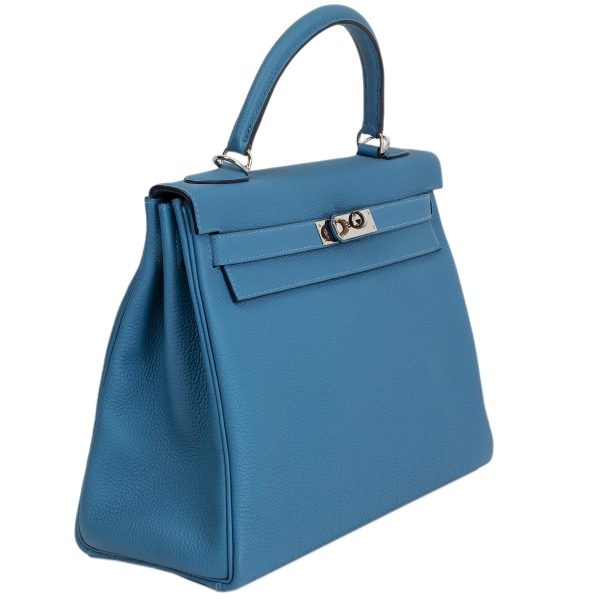 100% authentic Hermès Kelly II 32 Retourne bag in Azur blue Veau Togo leather with palladium hardware. Lined in Chevre (goat skin) with an open pocket against the front and a zipper pocket against the back. Has never been used and kept in the box -