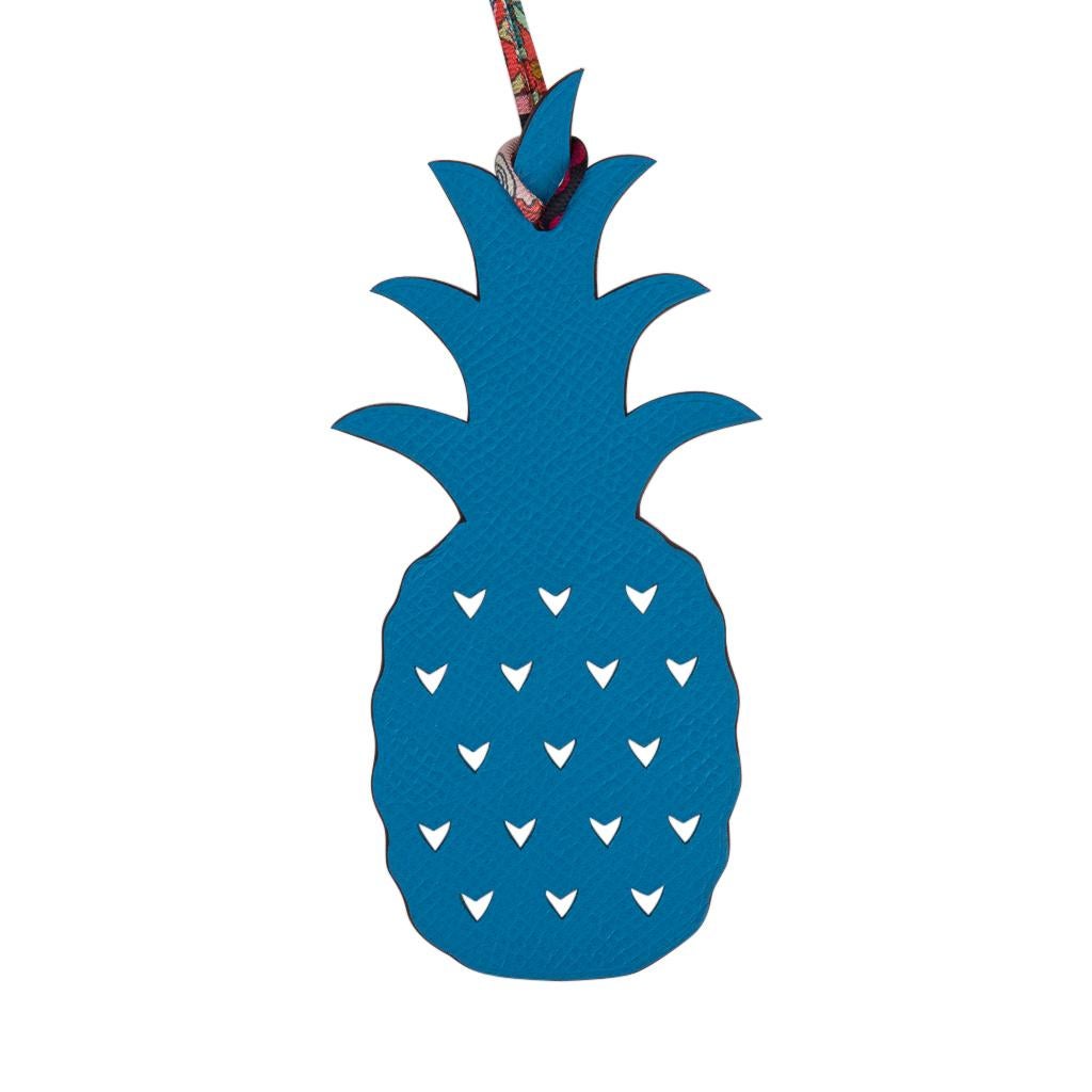 Guaranteed authentic coveted Hermes Petit h Bi-Color Pineapple calfskin bag charm with silk twill cord.
This whimsical charm features Rose Eglantine and Blue and can be worn as a bag charm or key holder.
Charming and playful she easily adorns a