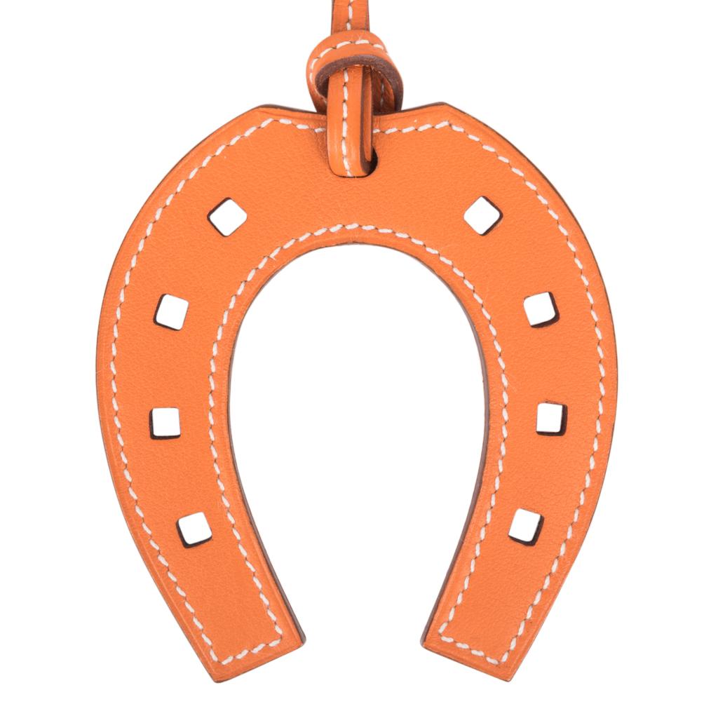 Guaranteed authentic Hermes Paddock Fer a Cheval Horse Shoe bag charm.
This equestrian charm is featured in rare Orange and will add a delightful touch to a myriad of your bags!
Stamped Hermes Paris Made in France.  
Comes with signature Hermes