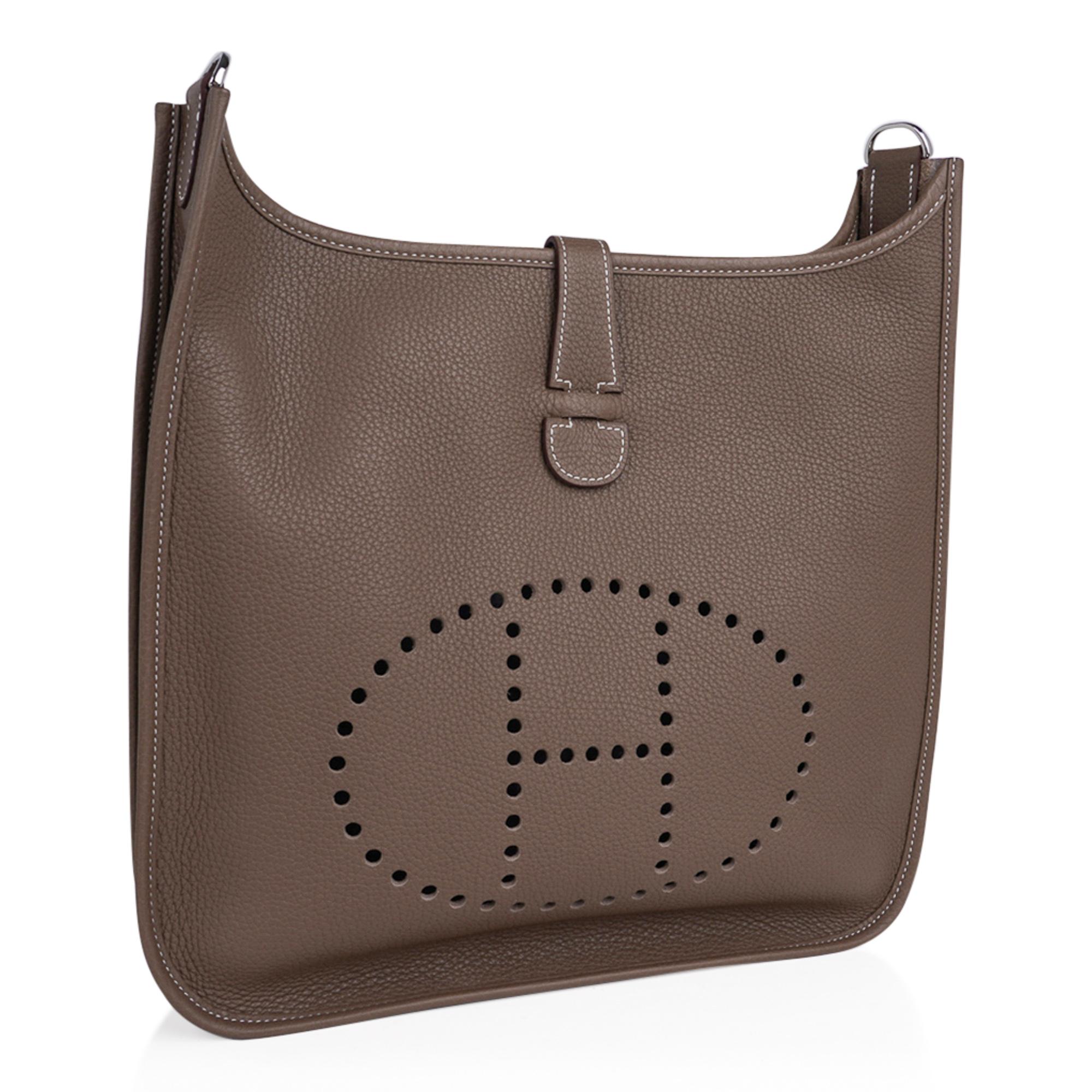 Mightychic offers an Hermes Evelyne GM featured in Etoupe clemence leather.  
Fabulous shoulder or cross body bag with roomy interior and rear outside deep pocket. 
Sport strap in textile with leather and palladium hardware details.
Signature