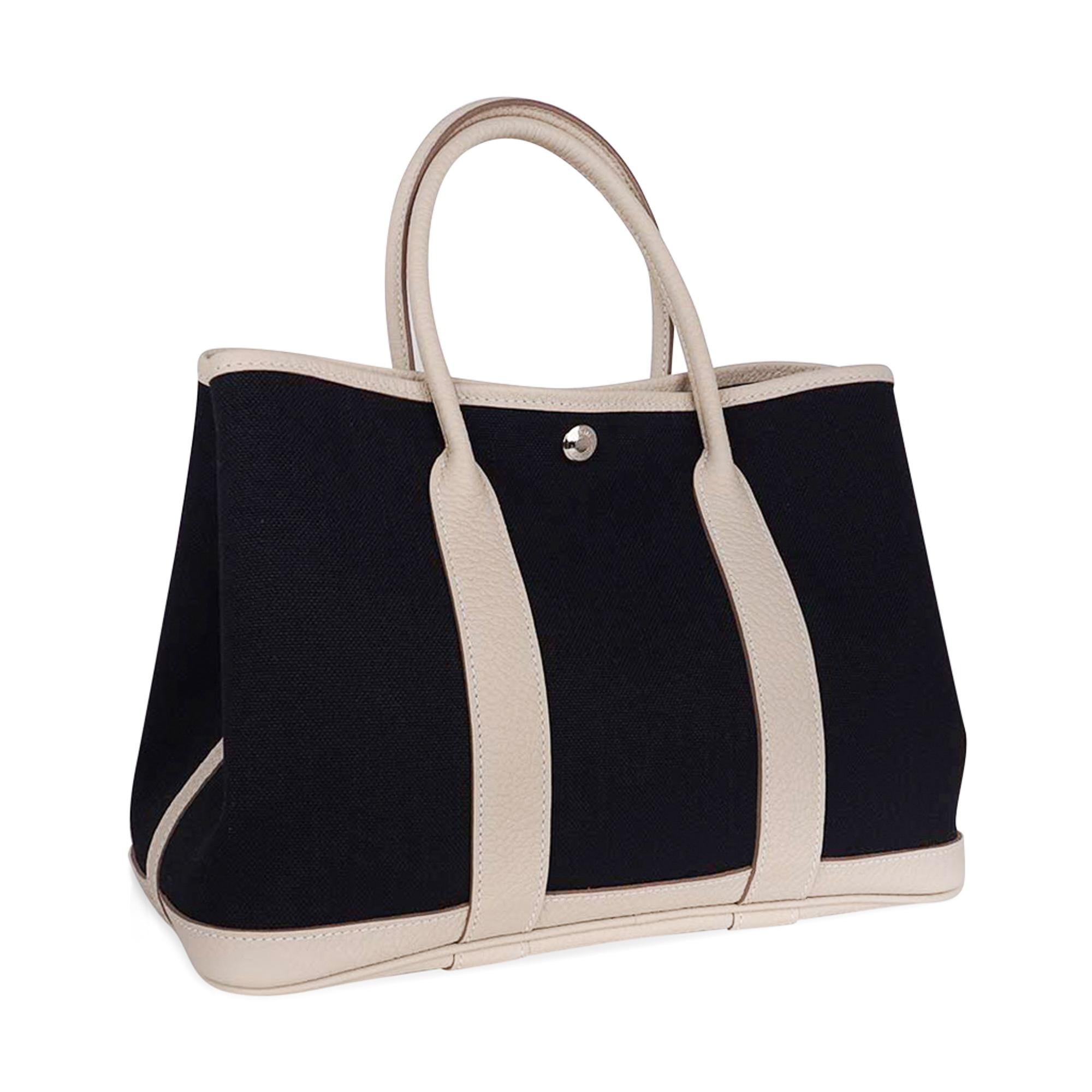 Mightychic offers a guaranteed authentic Hermes Garden Party 30 bag featured in Black Toile and Craie Negonda leather.
Accentuated with palladium Clou de Selle.
Interior is canvas lining and leather base.
Comes with signature Hermes box and