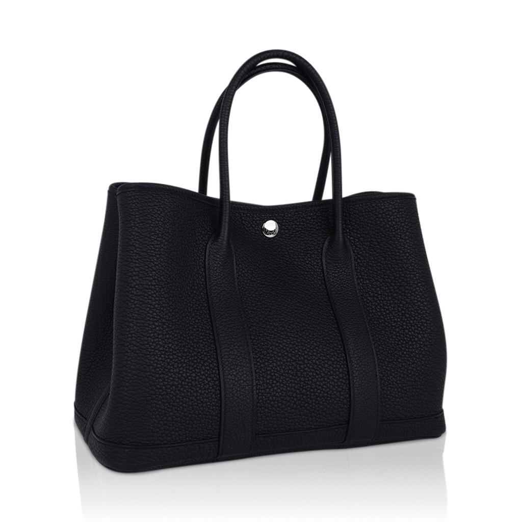 Mightychic offers an Hermes Garden Party 30 bag featured in Black Vache Country Leather.
This sleek, simple clean lined Hermes tote bag is the perfect about town tote.
Accentuated with palladium Clou de Selle.
Chevron canvas lining and interior