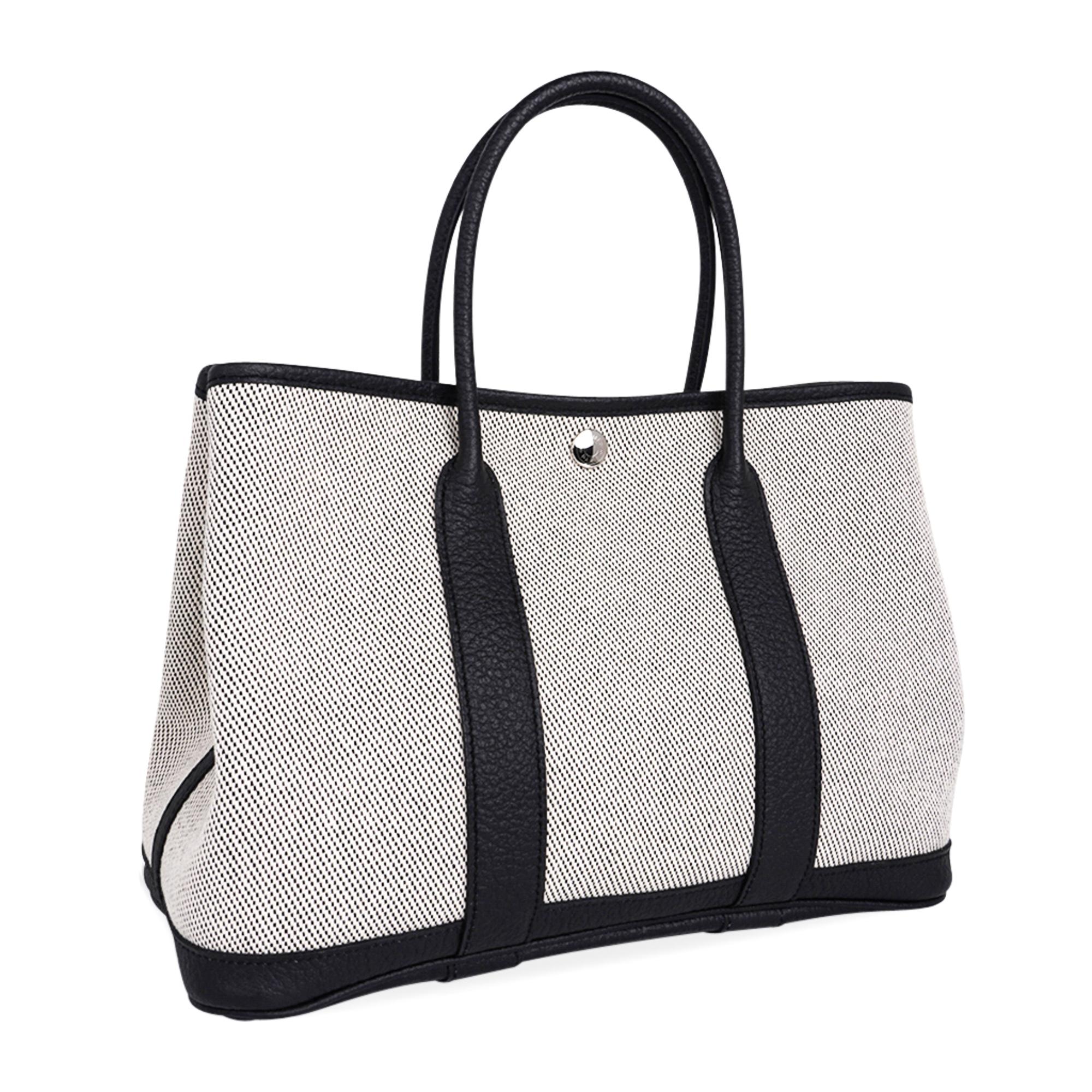 Mightychic offers a guaranteed authentic Hermes Garden Party 30 bag featured in Criss Cross Noir and Ecru Toile with Vache Country leather.
This crisp and fresh Garden Party 30 tote bag is the perfect about town tote. 
Durable and strong toile